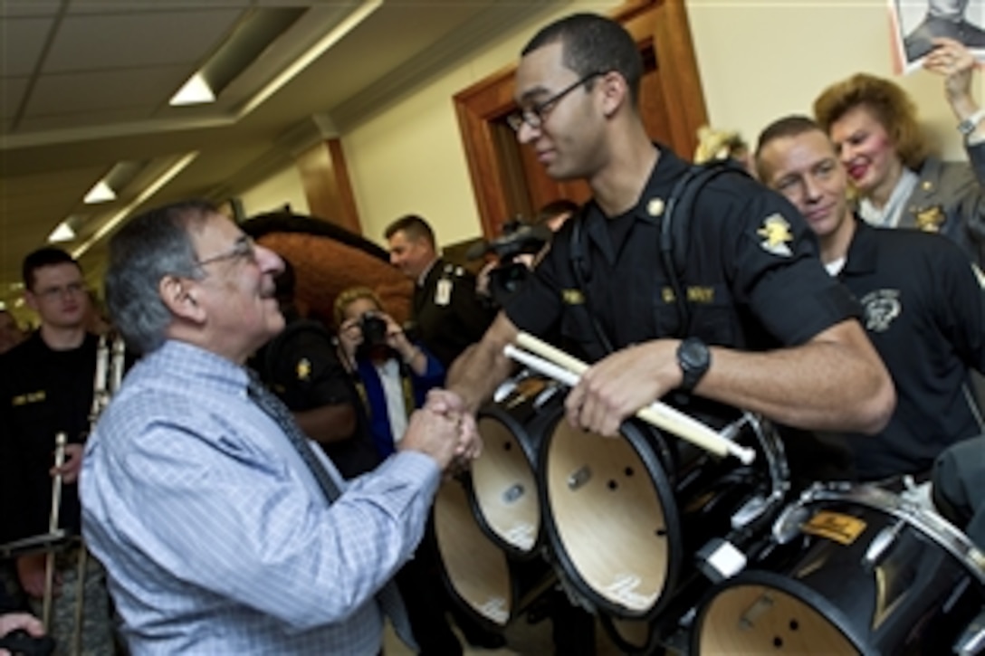 Defense Secretary Leon E. Panetta greets the U.S. Military Academy cheerleaders and band members during a pep rally held in the halls of the Pentagon, Dec. 7, 2012. Each year before the historic Army-Navy football game, which is set for Dec. 8, 2012, the Navy and Army pep squads conduct a rally at the Pentagon and visit the offices of senior Defense Department leaders. 