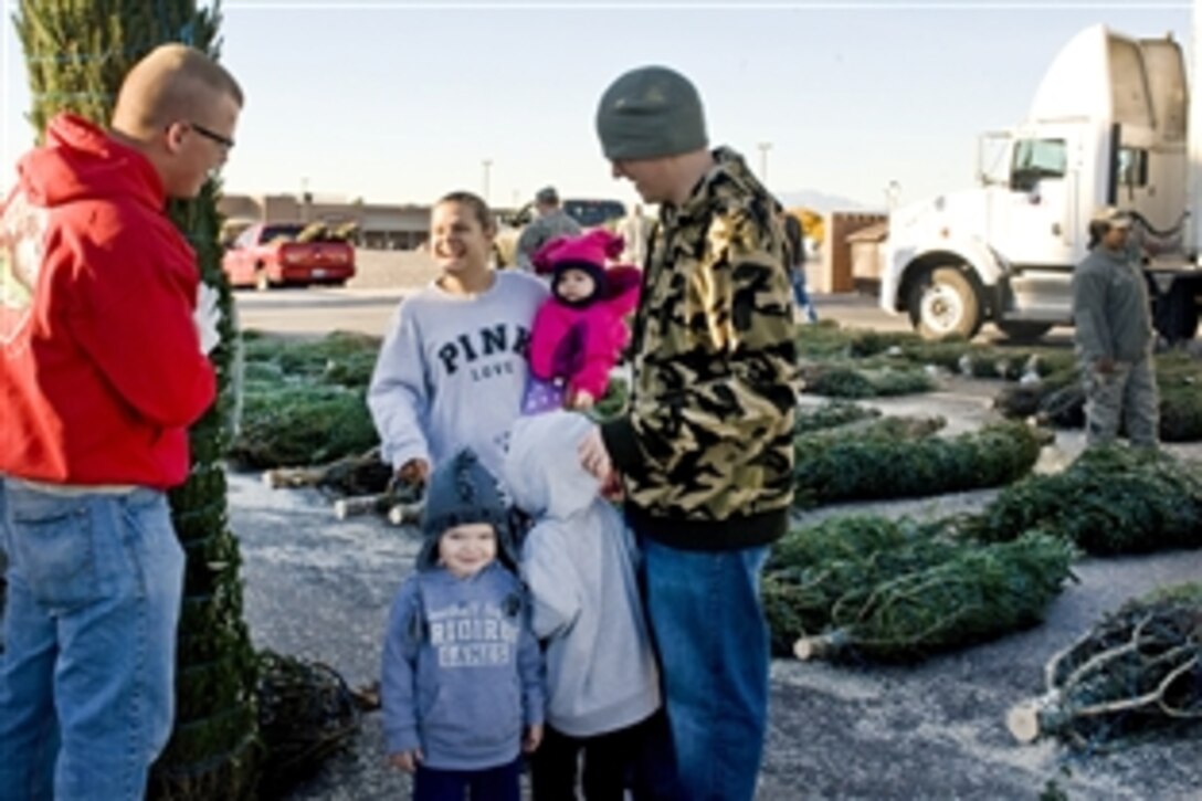 Airman 1st Class Brandon Fowler, 99th Civil Engineer Squadron, left, helps Staff Sgt. Mike Mullis and his family choose their Christmas tree during a Trees for Troops event at Nellis Air Force Base, Nev., Dec. 7, 2012. The Trees for Troops program is providing trees for active duty military members and their families for the eighth consecutive year. 
