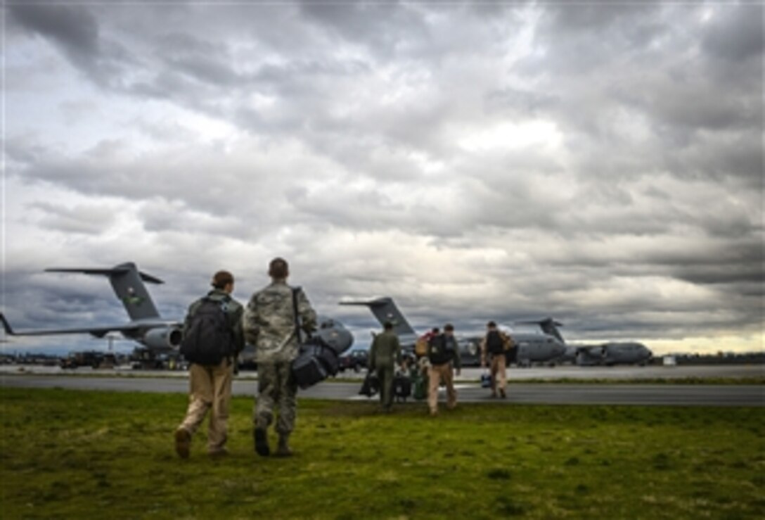 Airmen from the U.S. Air Force 10th Airlift Squadron walk across the airfield to a C-17 Globemaster III at Joint Base Lewis-McChord, Wash., on Nov. 29, 2012.  The airmen are beginning a two-month deployment where they will operate out of two bases to fly missions concentrated in and around Afghanistan, Iraq and the Horn of Africa. 