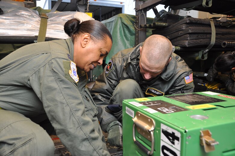 Capt. Brenda White, 43rd Aeromedical Evacuation Squadron flight nurse, and Master Sgt. Jason Longfellow, 43rd AES technician, secure oxygen onboard a KC-10 Extender at Travis Air Force Base Dec. 2. Inflight kits include about 750 pounds of AE equipment such as heart monitors, frequency converters, litters and oxygen.  (U.S. Air Force photo/1st Lt. Angela Martin)