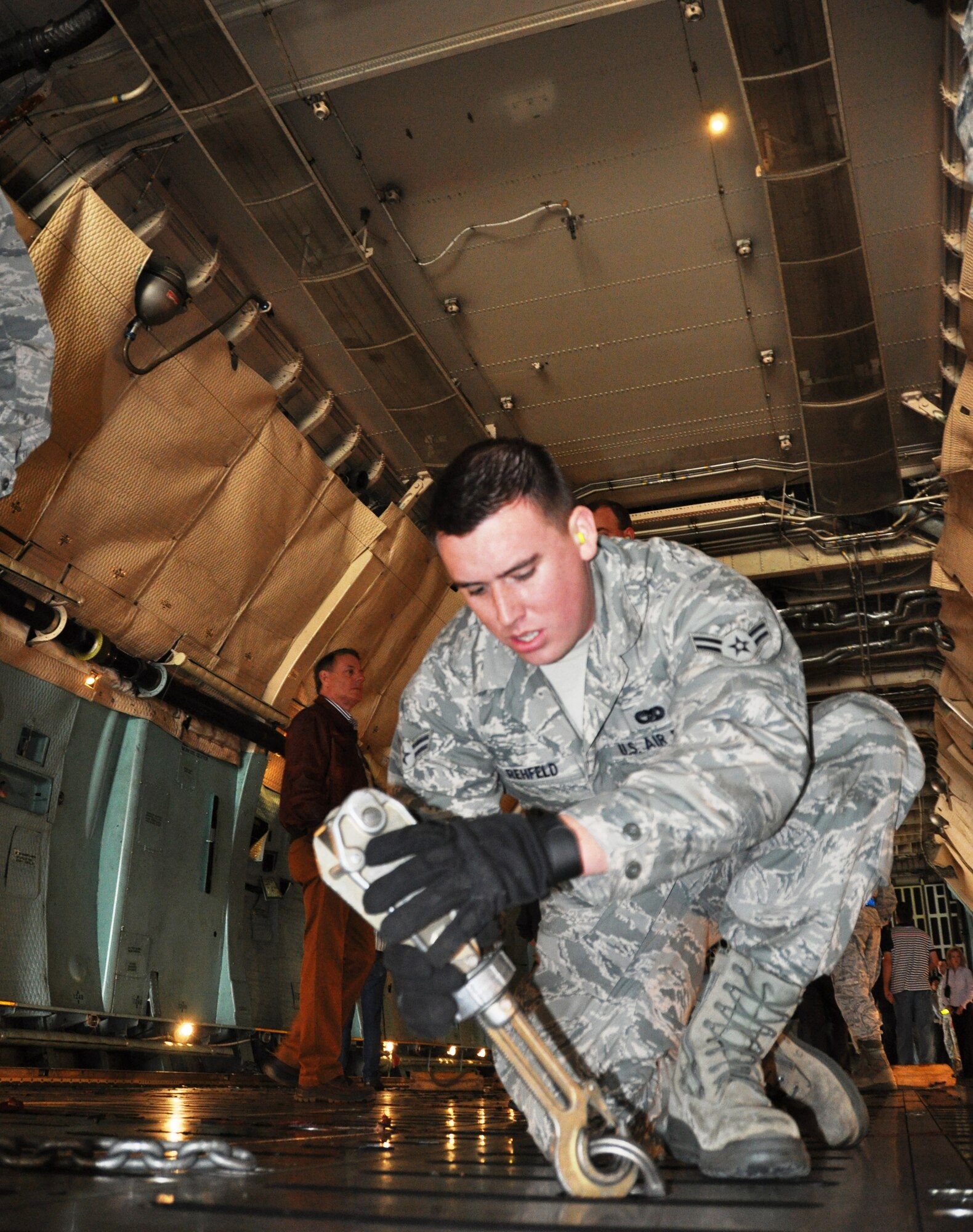 Airman 1st Class Adam Rehfeld, 26th Aerial Port Squadron, prepares to tie down a vehicle on board a C-5A Galaxy during a upload demonstration civilian employers.The 433rd Airlift Wing held its 19th Annual Employers' Day at Joint Base San Antonio-Lackland, Texas on Dec. 8, 2012. (Air Force photo/Tech Sgt. Carlos J. Trevino)