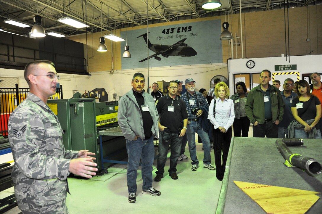 Senior Airman Kenan Torrance of the 433rd MXG, explains the role of maintainers in the the 433rd Airlift Wing. This was the 19th annual Employers' Day at Joint Base San Antonio-Lackland, Texas, Sat., Dec. 8, 2012. Civilian bosses of wing reservists flew aboard an Alamo Wing C-5A Galaxy, the largest aircraft in the U.S. Air Force inventory, and witnessed an in-flight aerial refueling mission with a KC-135 Stratotanker over West Texas.  (Air Force photo/Tech Sgt. Carlos J. Trevino)