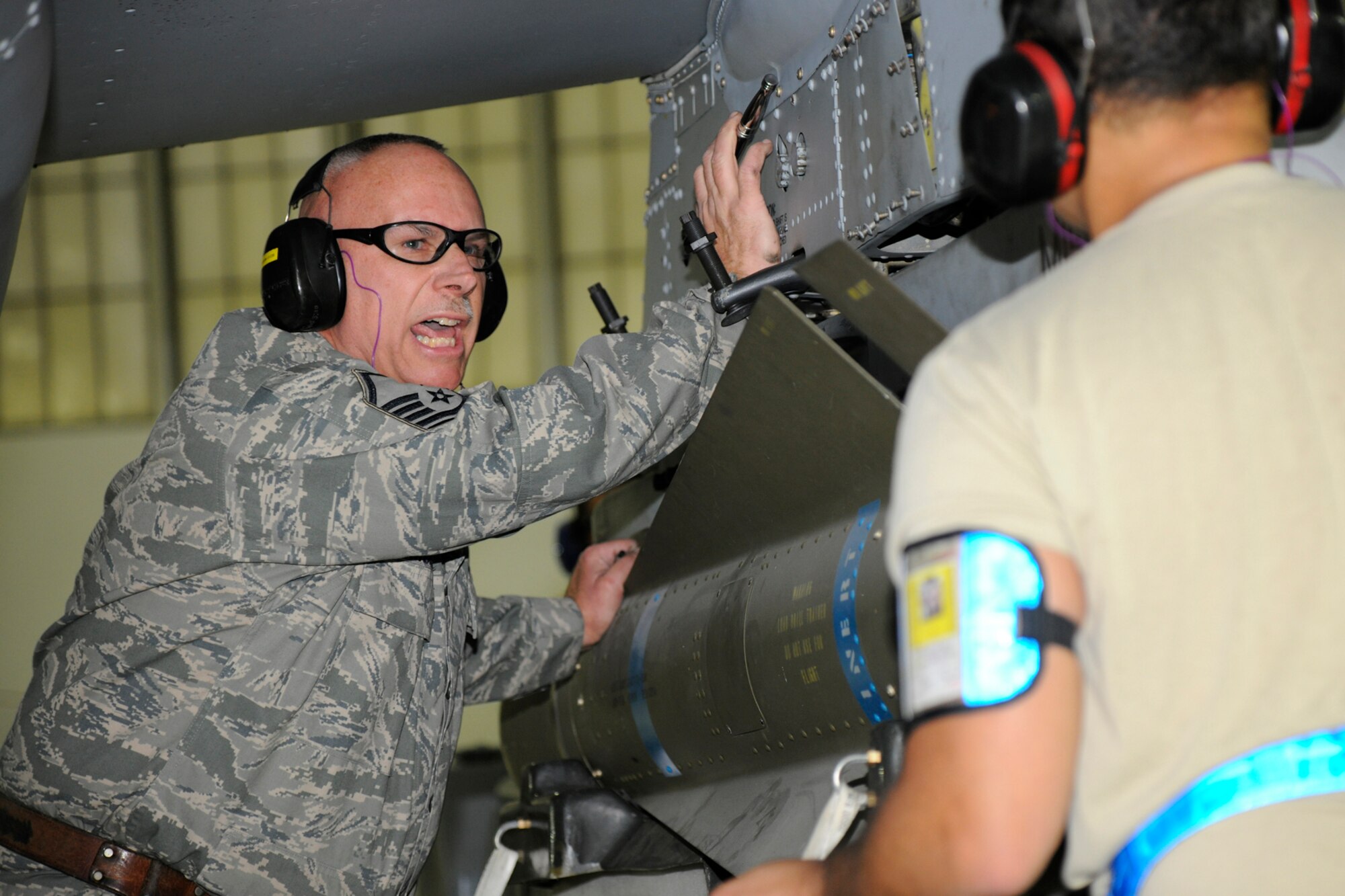 Master Sgt. Doug McGaw shouts an instruction to Airman 1st Class Ben Engel as they load a GBU 38 on to an A-10 Thunderbolt II aircraft during the 127th Aircraft Maintenance Squadron’s annual loadeo competition Dec. 8, 2012, at Selfridge Air National Guard Base, Mich. During the competition, weapons load crews are judged based on their knowledge of weapons systems and are graded while loading a series of bombs and missiles onto an A-10 Thunderbolt II aircraft. (Air National Guard photo by TSgt. David Kujawa)
