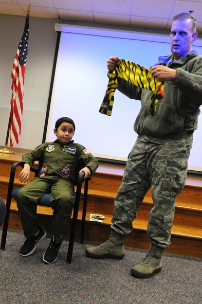 JOINT BASE ANDREWS, Md. -- Col. William H. Mason, 459th Air Refueling Wing commander, provides a pilot's scarf to Melvin Maldonado, 10,  during Team Andrew's Pilot for a Day program here Dec. 7, 2012. The Pilot for a Day program is coordinated through the Air Force Reserve Command's 459th ARW and the District of Columbia Air National Guard's 113th Wing. Pilot for a Day or "P4D" is a community outreach program that allows military and civilian children of all ages who suffer from serious or chronic medical conditions to visit an installation for the day to tour wing and base facilities. (U.S. Air Force photo/Tech Sgt Steve Lewis)