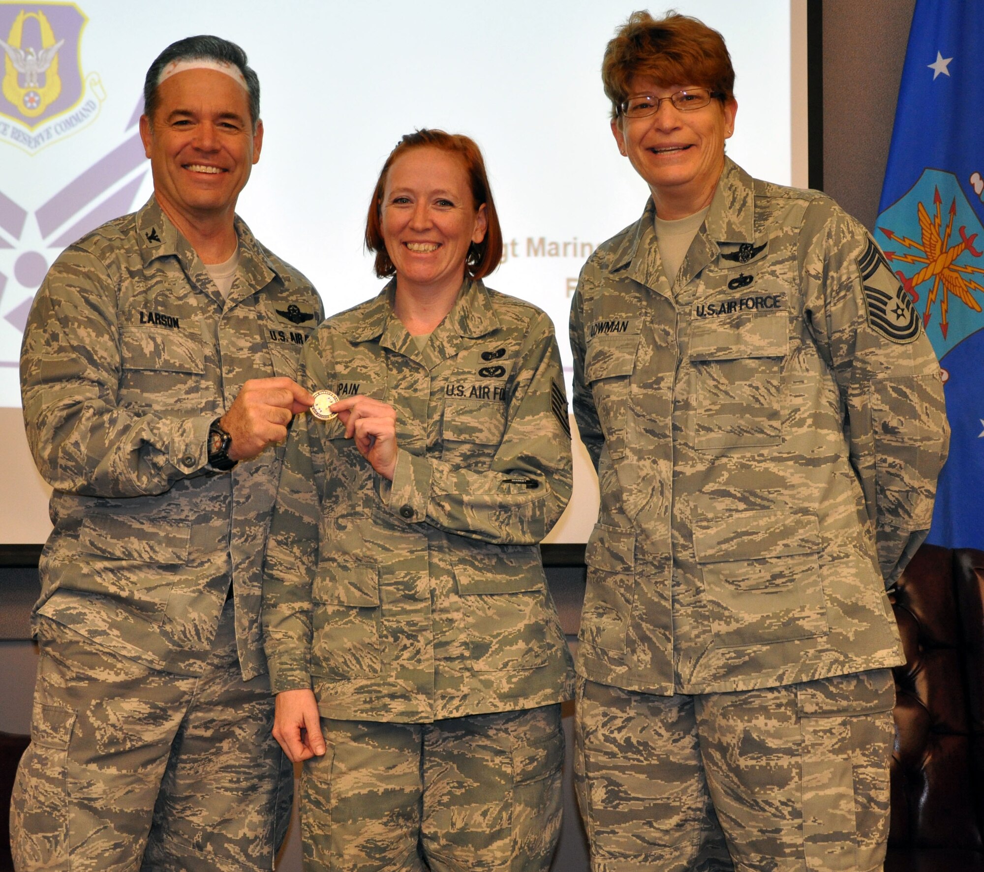 Tech. Sgt. Stacey Spain, 931st Civil Engineer Squadron, is presented with a commander's coin from 931st Air Refueling Group commander, Col. Mark S. Larson, during the 931st Civil Engineer Squadron commander's call, Dec. 9, 2012.  Spain was recognized by Larson and Chief Master Sgt. Kathleen E. Lowman, 931 ARG Superintendent for performing above and beyond in helping the Group to achieve and maintain all around mission readiness.  (U.S. Air Force photo by 1st Lt. Zach Anderson)