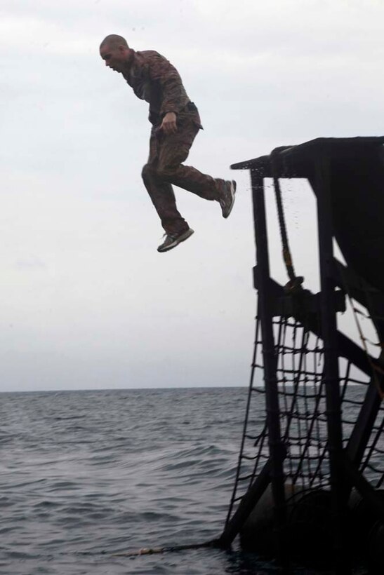 A Marine with Battalion Landing Team 3/5, 15th Marine Expeditionary Unit jumps off a water obstacle course at the French Combat Warfare Training Center in Djibouti, Dec. 4. The training, led by instructors from French forces of the French CWTC in Djibouti, involved obstacle courses on land and in the water different from ones Marines and sailors are used to seeing back home. The 15th MEU is deployed as part of the Peleliu Amphibious Ready Group as a U.S. Central Command theater reserve force, providing support for maritime security operations and theater security cooperation efforts in the U.S. 5th Fleet area of responsibility. (U.S. Marine Corps photo by Cpl. John Robbart III)
