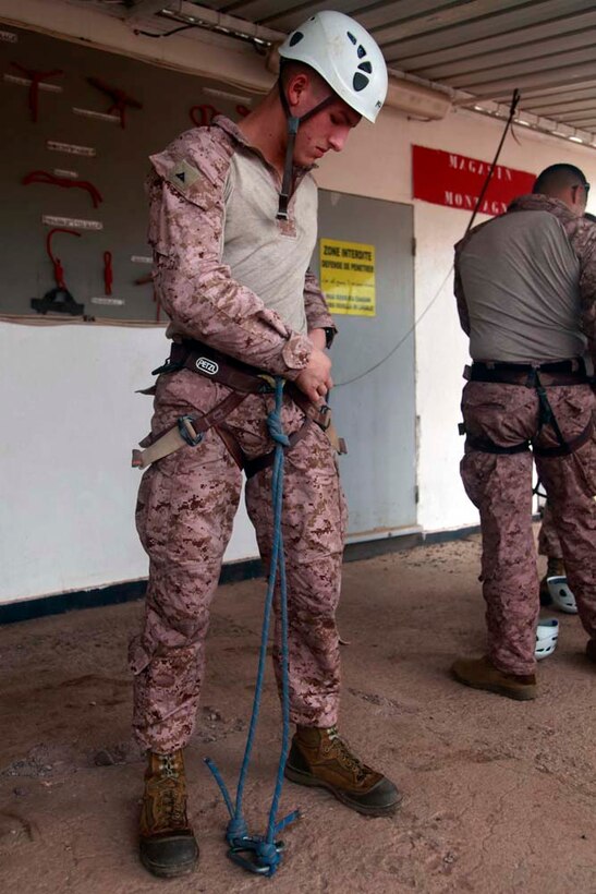 Lance Cpl. Kelly J. Schaefer, assessment consequence management team member, Chemical Biological Radiological Nuclear Defense Detachment, Command Element, 15th Marine Expeditionary Unit, secures his harness before conducting a team-building obstacle course at the French Combat Warfare Training Center in Djibouti, Dec. 4. The training, led by instructors from French forces of the French CWTC in Djibouti, involved obstacle courses on land and in the water different from ones Marines and sailors are used to seeing back home. The 15th MEU is deployed as part of the Peleliu Amphibious Ready Group as a U.S. Central Command theater reserve force, providing support for maritime security operations and theater security cooperation efforts in the U.S. 5th Fleet area of responsibility. Schaefer, 20, is from Fraser, Mich. (U.S. Marine Corps photo by Cpl. John Robbart III)