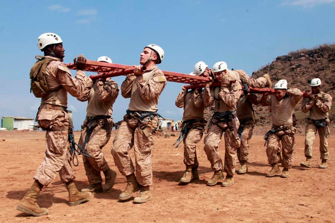 Marines and sailors with Battalion Landing Team 3/5, 15th Marine Expeditionary Unit, work as a team to carry a simulated casualty during a team-building obstacle course at the French Combat Warfare Training Center in Djibouti, Dec. 4. The training, led by instructors from French forces of the French CWTC in Djibouti, involved obstacle courses on land and in the water different from ones Marines and sailors are used to seeing back home. The 15th MEU is deployed as part of the Peleliu Amphibious Ready Group as a U.S. Central Command theater reserve force, providing support for maritime security operations and theater security cooperation efforts in the U.S. 5th Fleet area of responsibility. (U.S. Marine Corps photo by Cpl. John Robbart III)