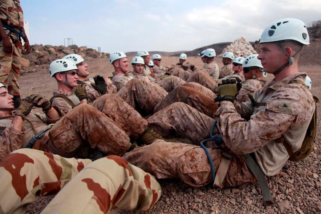 Marines and sailors with Battalion Landing Team 3/5, 15th Marine Expeditionary Unit, conduct buddy sit-ups during a team-building obstacle course at the French Combat Warfare Training Center in Djibouti, Dec. 4. The training, led by instructors from French forces of the French CWTC in Djibouti, involved obstacle courses on land and in the water different from ones Marines and sailors are used to seeing back home. The 15th MEU is deployed as part of the Peleliu Amphibious Ready Group as a U.S. Central Command theater reserve force, providing support for maritime security operations and theater security cooperation efforts in the U.S. 5th Fleet area of responsibility. (U.S. Marine Corps photo by Cpl. John Robbart III)