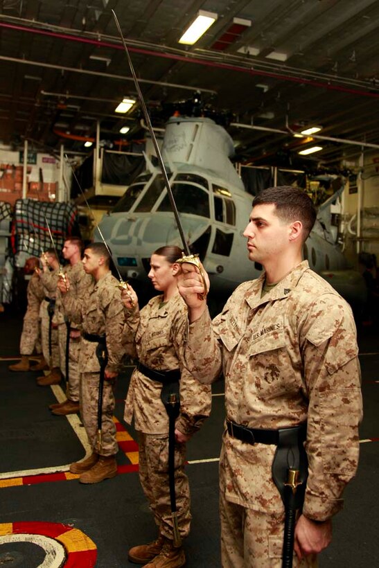 Corporals with the 15th Marine Expeditionary Unit, practice sword manual in the hangar bay of the USS Peleliu during Corporal's Course, Dec. 3. Corporals' Course is a professional military education for enlisted Marines designed to give them the tools to become better effective small unit leaders. The 15th MEU is deployed as part of the Peleliu Amphibious Ready Group as a U.S. Central Command theater reserve force, providing support for maritime security operations and theater security cooperation efforts in the U.S. 5th Fleet area of responsibility. (U.S. Marine Corps photo by Cpl. John Robbart III)