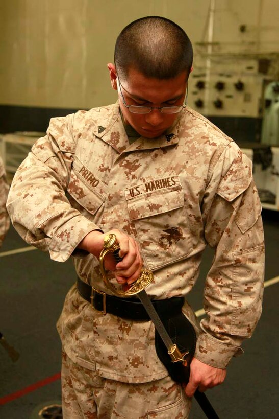 Corporal Angel A. Primo, avionics technician, Marine Medium Helicopter Squadron 364 (Rein.), 15th Marine Expeditionary Unit, practices sword manual in the hangar bay of the USS Peleliu during Corporal's Course, Dec. 3. Corporals' Course is a professional military education for enlisted Marines designed to give them the tools to become better effective small unit leaders. The 15th MEU is deployed as part of the Peleliu Amphibious Ready Group as a U.S. Central Command theater reserve force, providing support for maritime security operations and theater security cooperation efforts in the U.S. 5th Fleet area of responsibility. Primo, 22, is from Los Angeles. (U.S. Marine Corps photo by Cpl. John Robbart III)