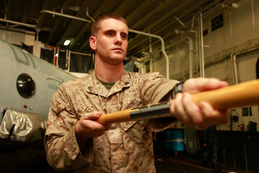Corporal Chris S. Eccard, squad leader, Kilo Company, Battalion Landing Team 3/5, 15th Marine Expeditionary Unit, practices guidon manual in the hangar bay of the USS Peleliu during Corporal's Course, Dec. 3. Corporals' Course is a professional military education for enlisted Marines designed to give them the tools to become better effective small unit leaders. The 15th MEU is deployed as part of the Peleliu Amphibious Ready Group as a U.S. Central Command theater reserve force, providing support for maritime security operations and theater security cooperation efforts in the U.S. 5th Fleet area of responsibility. Eccard, 24, is from Cincinnati, Ohio. (U.S. Marine Corps photo by Cpl. John Robbart III)