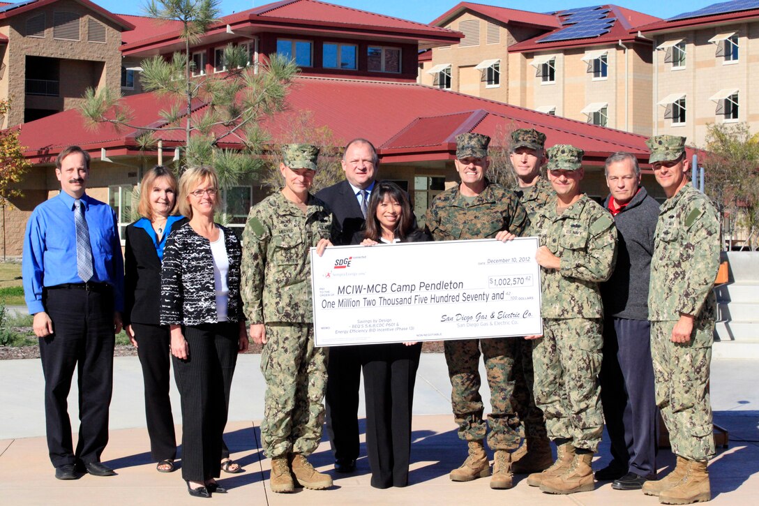 Caroline Winn, center, and Brig. Gen. Vincent A. Coglianese, center-right, pose with other participants of the Savings by Design program, which assists in lowering the long-term energy costs of building projects.  Winn, the vice president of San Diego Gas and Electric, presented a check for $1,002,570.42  to Coglianese, the base commanding general and regional authority for five Marine Corps installations in the Southwestern United States Dec. 10.