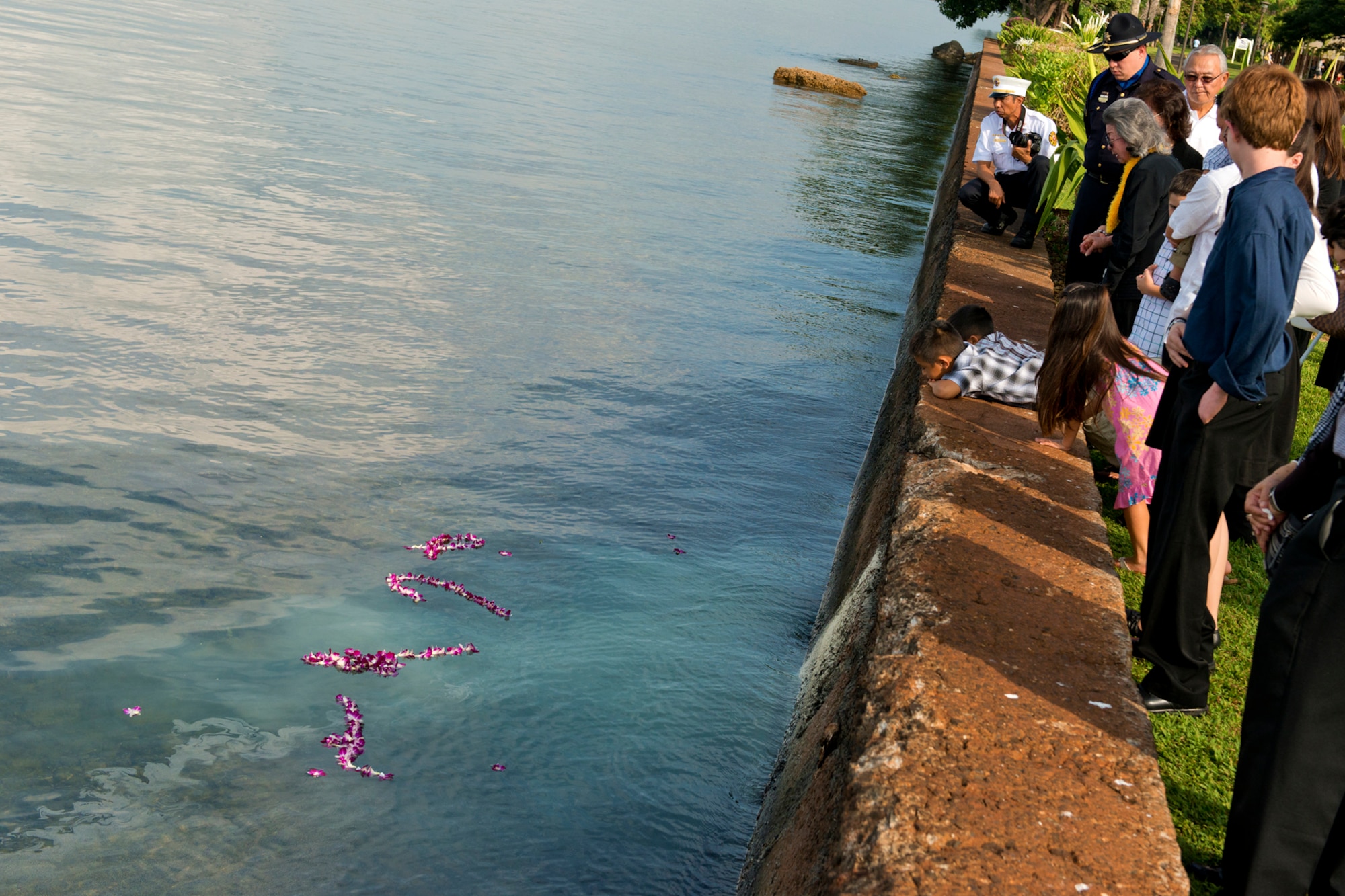 The family of Senior Master Sgt. (Ret.) Raymond Perry, peer into the waters of Pearl Harbor where his remains were spread after his ash scattering ceremony Dec. 7, 2012 at Joint Base Pearl Harbor-Hickam, Hawaii. Perry was a Dec. 7, 1941, Hickam Field attack survivor whose wishes were for his family to return him to Hickam and spread his ashes. He served 26-years in the Air Force and was a founding member of the pararescue career field. He returned to Hickam and serve for more than 20 years as a fire inspector for the Hickam fire department. This is the first time a Hickam Field survivor has had their remains scattered at Hickam Field. (U.S. Air Force photo/Staff Sgt. Mike Meares)