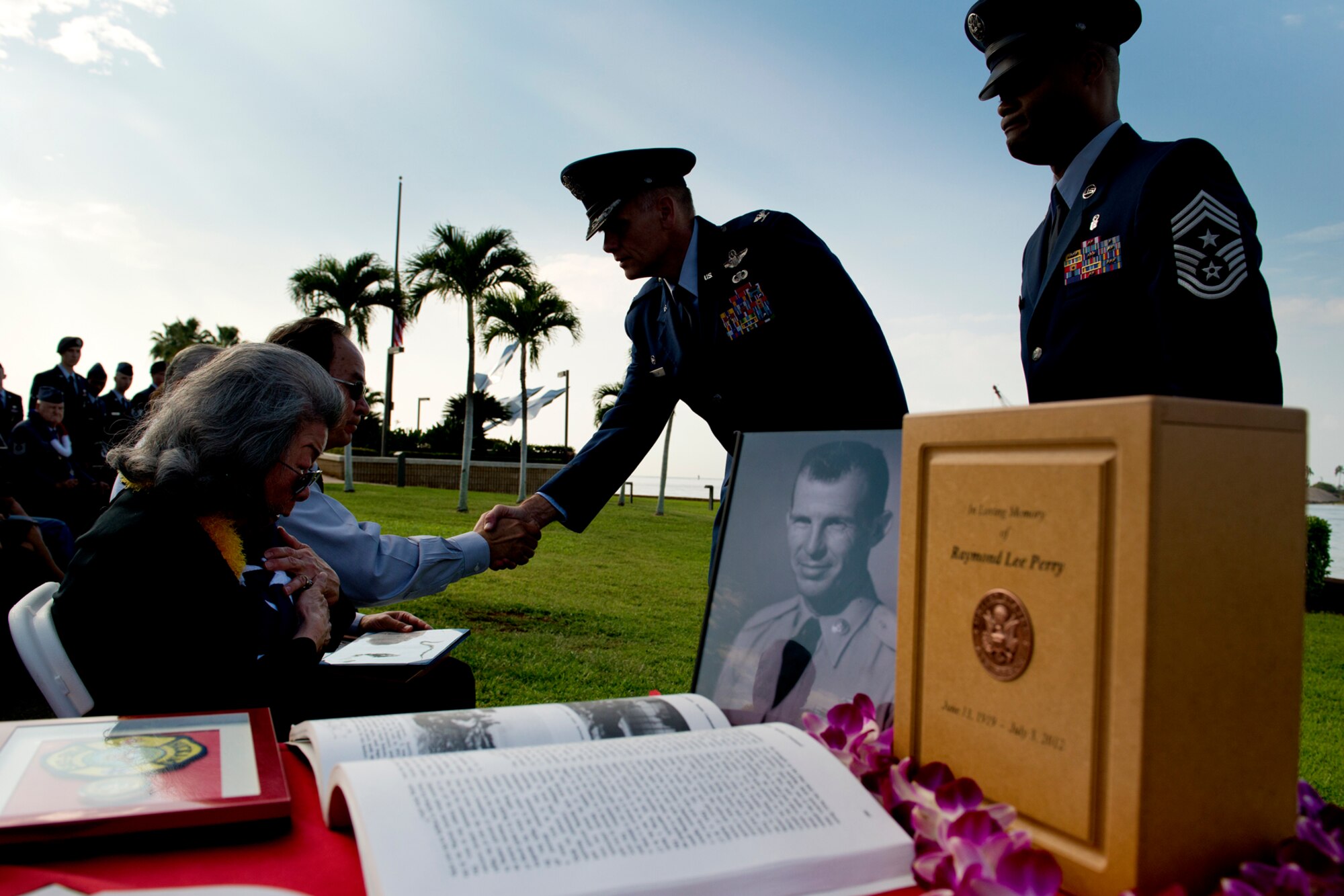 Elizabeth Chew Perry, widow of Senior Master Sgt. (Ret.) Raymond Perry, clutches a folded American flag during his ash scattering ceremony Dec. 7, 2012 at Joint Base Pearl Harbor-Hickam, Hawaii. Perry was a Dec. 7, 1941, Hickam Field attack survivor whose wishes were for his family to return him to Hickam and spread his ashes. He served 26-years in the Air Force and was a founding member of the pararescue career field. He returned to Hickam and served for more than 20 years as a fire inspector for the Hickam fire department. (U.S. Air Force photo/Staff Sgt. Mike Meares)