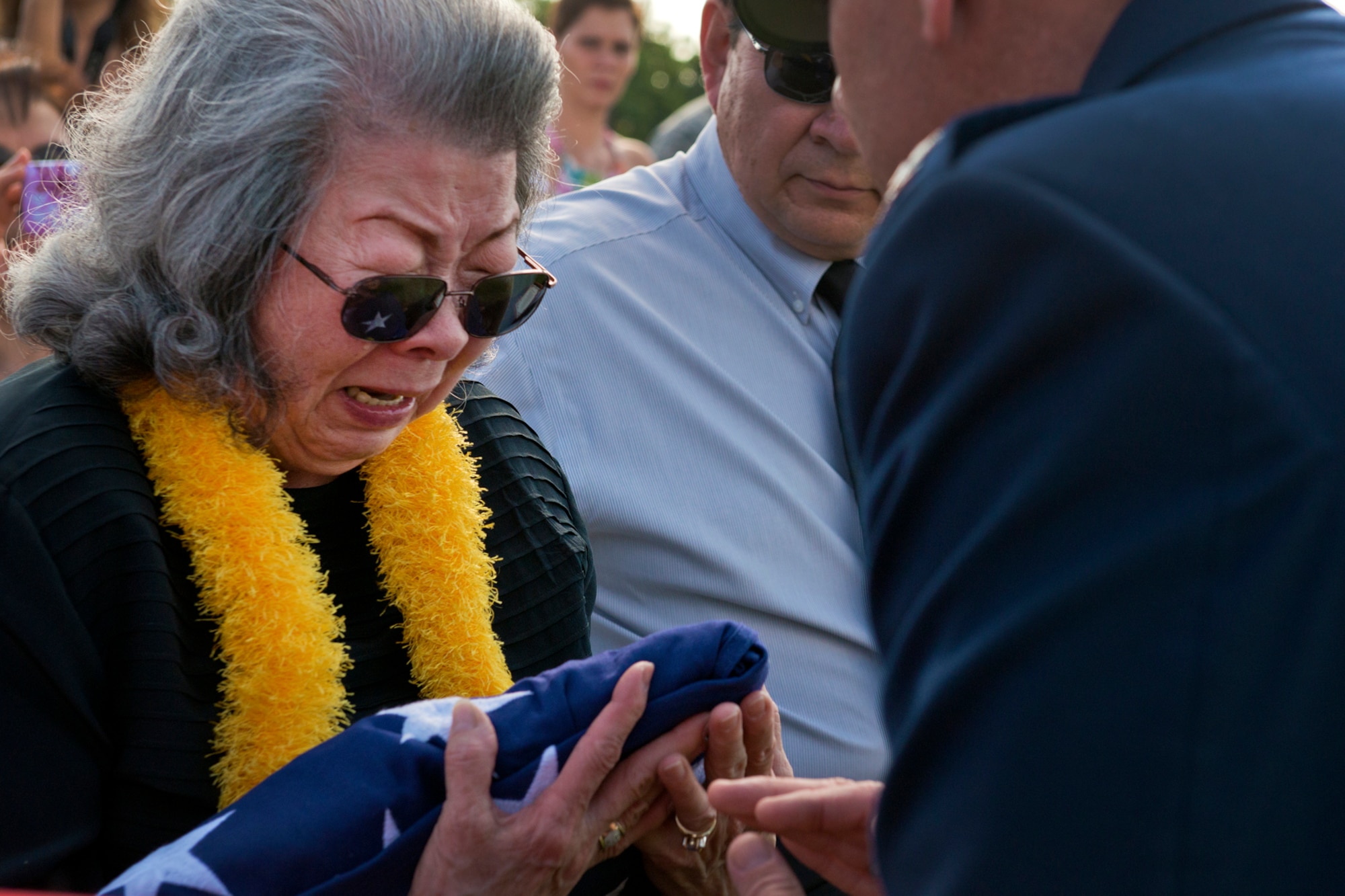 Elizabeth Chew Perry, widow of Senior Master Sgt. (Ret.) Raymond Perry, receives a folded American flag from Col. Johnny Roscoe, 15th Wing commander, during his ash scattering ceremony Dec. 7, 2012 at Joint Base Pearl Harbor-Hickam, Hawaii. Perry was a Dec. 7, 1941, Hickam Field attack survivor whose wishes were for his family to return him to Hickam and spread his ashes. He served 26-years in the Air Force and was a founding member of the pararescue career field. He returned to Hickam and serve for more than 20 years as a fire inspector for the Hickam fire department. (U.S. Air Force photo/Staff Sgt. Mike Meares)