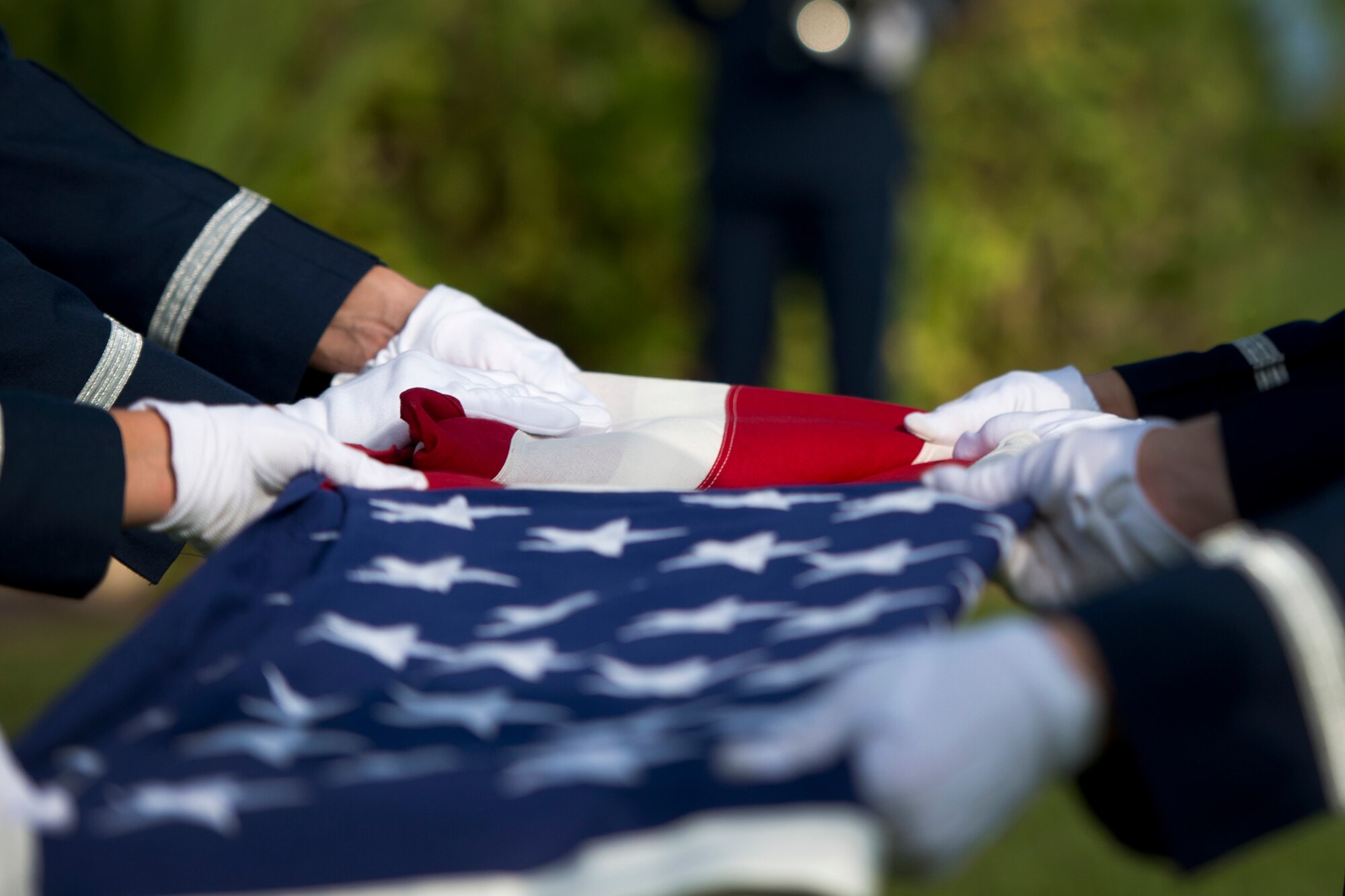 The Hickam Honor Guard ceremonially folds an American flag during the ash scattering ceremony of Senior Master Sgt. (Ret.) Raymond L. Perry, Dec. 7, 2012 at Hickam Field, Joint Base Pearl Harbor-Hickam, Hawaii. Perry was a Dec. 7, 1941, Hickam Field attack survivor whose wishes were for his family to return him to Hickam and spread his ashes. He served 26-years in the Air Force and was a founding member of the pararescue career field. He returned to Hickam and serve for more than 20 years as a fire inspector for the Hickam fire department. (U.S. Air Force photo/Staff Sgt. Mike Meares)