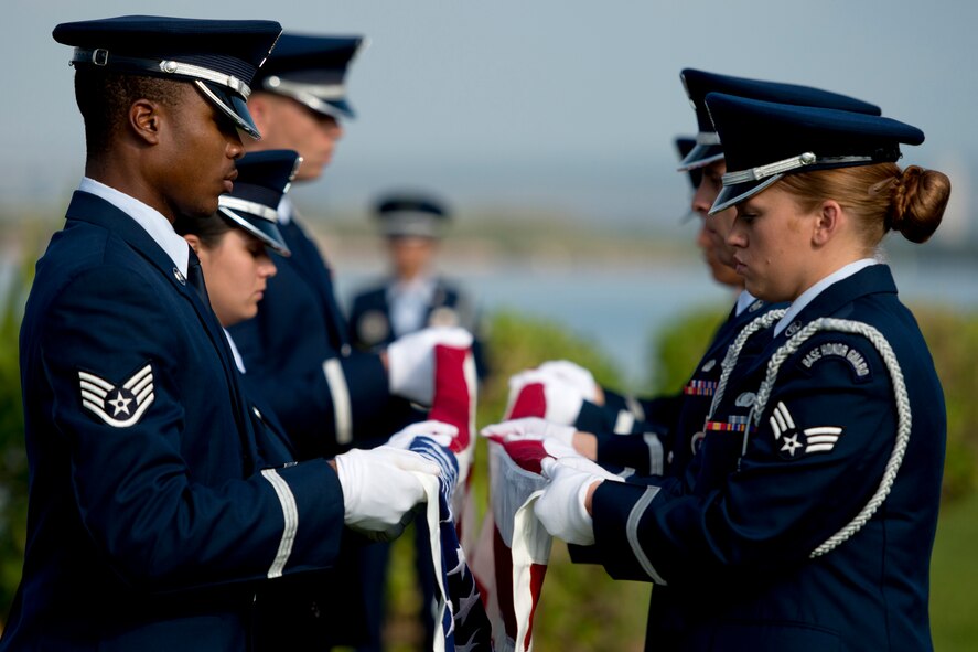 The Hickam Honor Guard ceremonially folds an American flag during the ash scattering ceremony of Senior Master Sgt. (Ret.) Raymond L. Perry, Dec. 7, 2012 at Hickam Field, Joint Base Pearl Harbor-Hickam, Hawaii. Perry was a Dec. 7, 1941, Hickam Field attack survivor whose wishes were for his family to return him to Hickam and spread his ashes. He served 26-years in the Air Force and was a founding member of the pararescue career field. He returned to Hickam and serve for more than 20 years as a fire inspector for the Hickam fire department. (U.S. Air Force photo/Staff Sgt. Mike Meares)