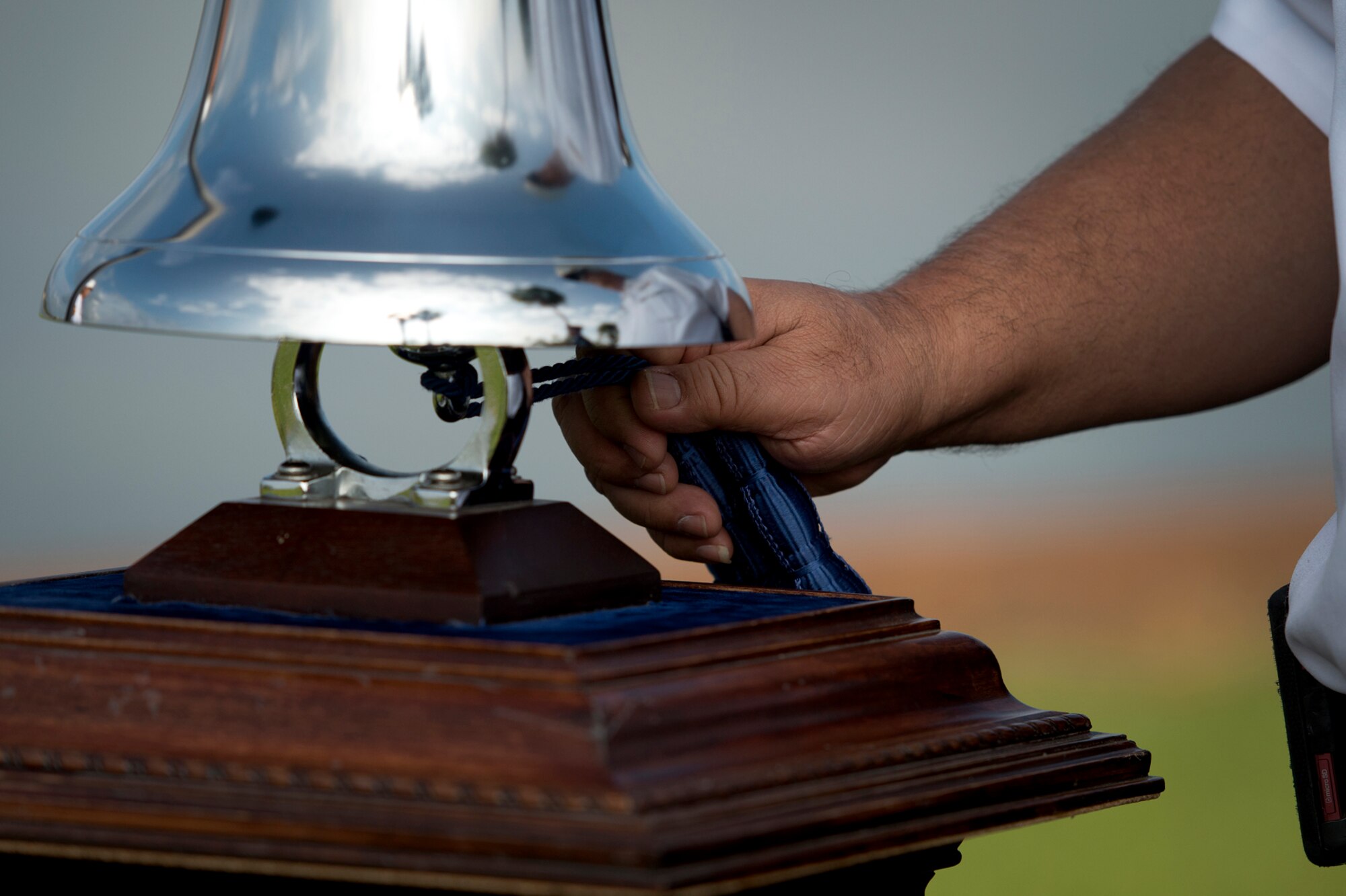Federal Fire Department Assistant Chief George Crowder tolls the bell for Senior Master Sgt. (Ret.) Raymond Perry, before his ash scattering ceremony Dec. 7, 2012 at Joint Base Pearl Harbor-Hickam, Hawaii. Perry was a Dec. 7, 1941, Hickam Field attack survivor whose wishes were for his family to return him to Hickam and spread his ashes. He served 26-years in the Air Force and was a founding member of the pararescue career field. He returned to Hickam and serve for more than 20 years as a fire inspector for the Hickam fire department. (U.S. Air Force photo/Staff Sgt. Mike Meares)