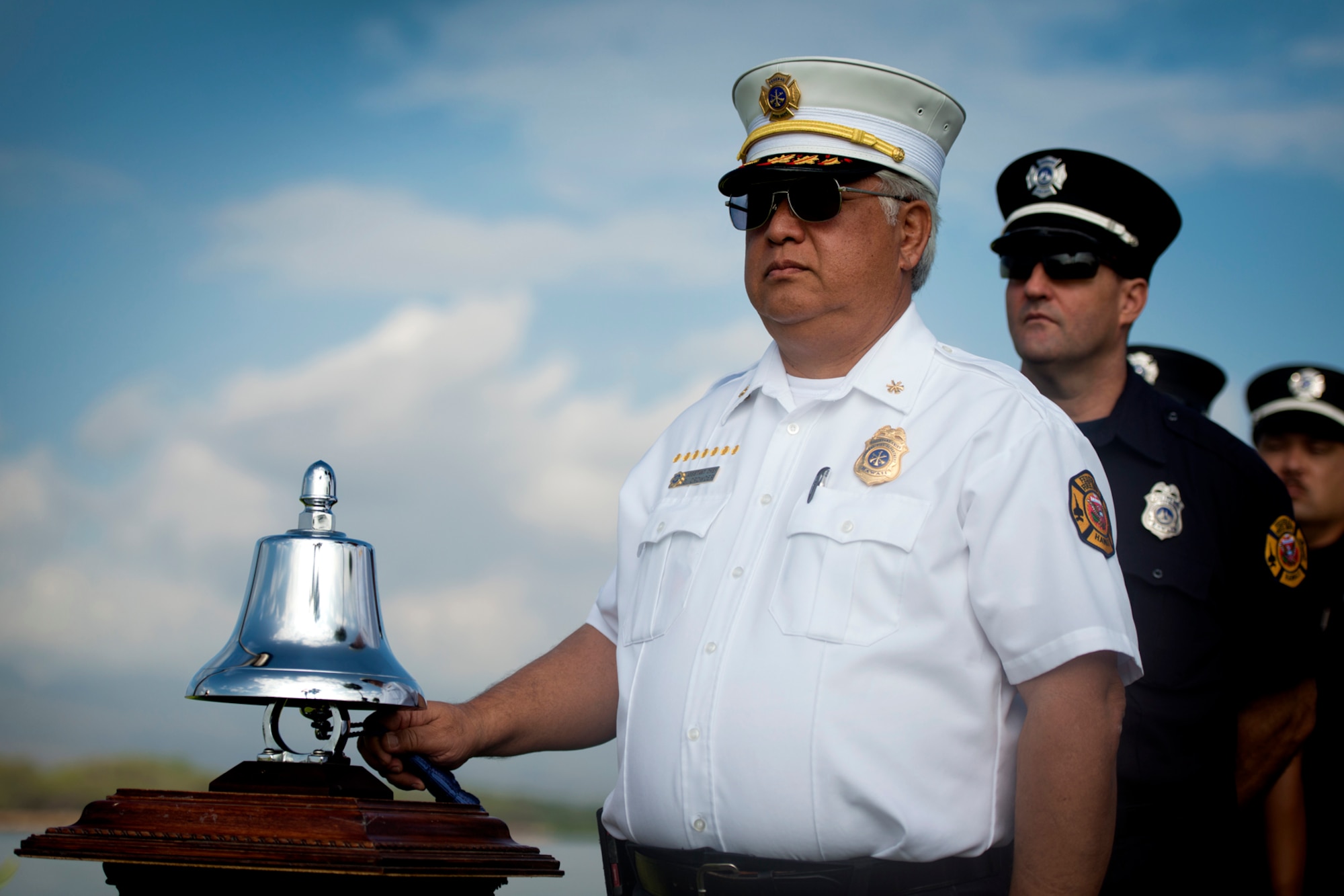 Federal Fire Department Assistant Chief George Crowder tolls the bell for Senior Master Sgt. (Ret.) Raymond Perry, before his ash scattering ceremony Dec. 7, 2012 at Joint Base Pearl Harbor-Hickam, Hawaii. Perry was a Dec. 7, 1941, Hickam Field attack survivor whose wishes were for his family to return him to Hickam and spread his ashes. He served 26-years in the Air Force and was a founding member of the pararescue career field. He returned to Hickam and serve for more than 20 years as a fire inspector for the Hickam fire department. (U.S. Air Force photo/Staff Sgt. Mike Meares)