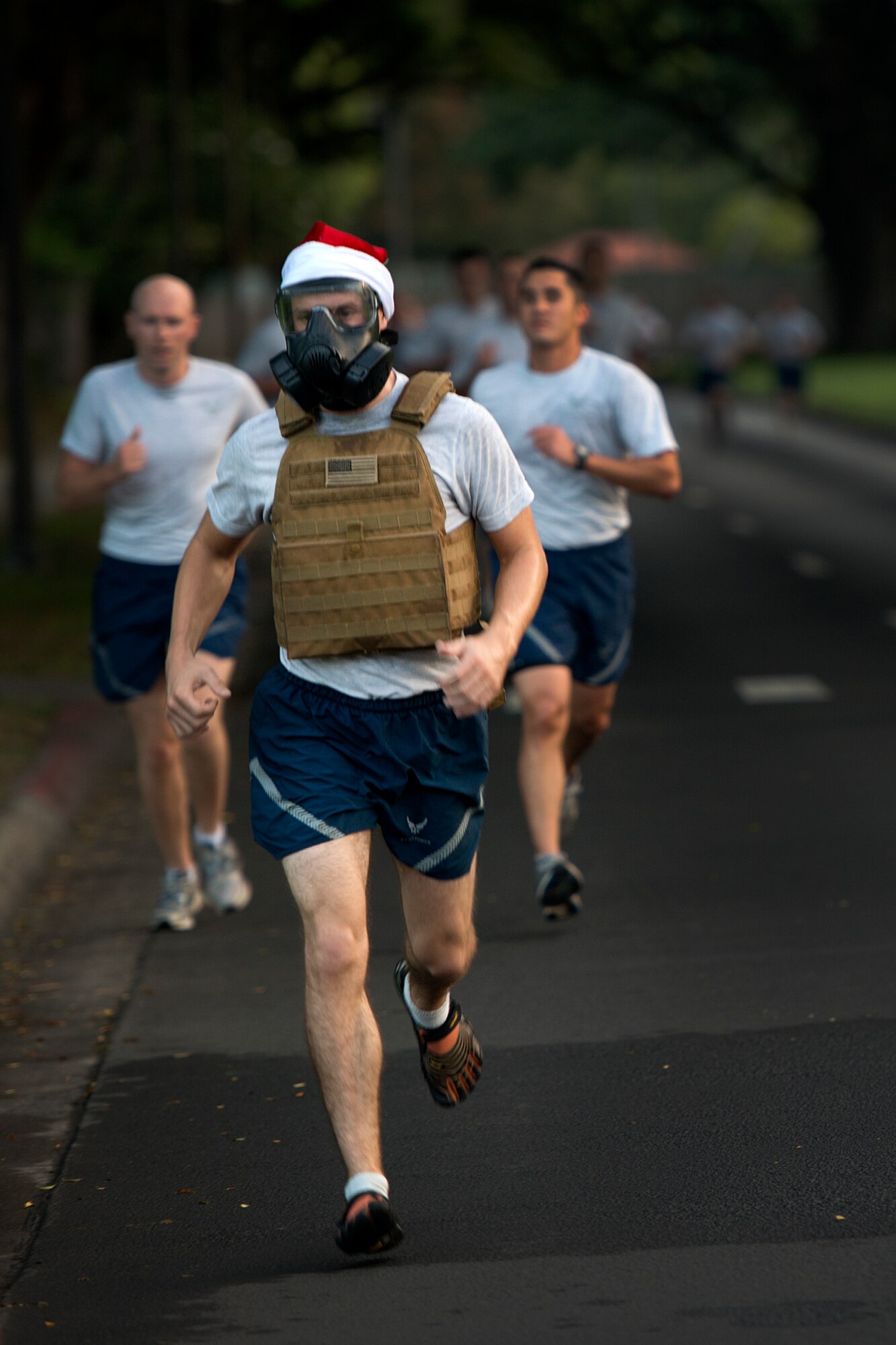 Senior Airman Aaron Allor, 647th Civil Engineer Squadron engineering technician, sports a gas mask and Santa hat during the 2.2-mile monthly fun run Dec. 6, 2012, on Hickam Field, Joint Base Pearl Harbor-Hickam, Hawaii. The joint service run is typically held the first Friday of each month, but was moved for Dec. 7 ceremonies. (U.S. Air Force Base photo/Staff Sgt. Mike Meares)