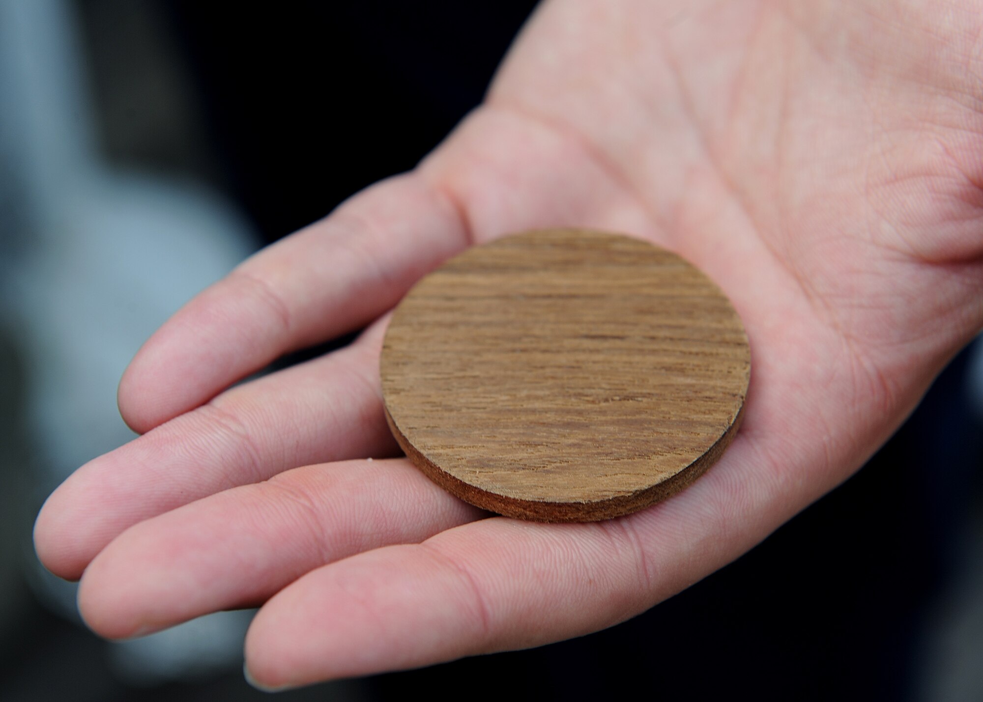 A service member holds a special wood token, cut from the deck of the USS Missouri Memorial, Pearl Harbor, Hawaii, Dec. 7, 2012. The tokens were given to all the new enlistees to celebrate their re-enlistment aboard the historic battleship and to commemorate the 71st anniversary of the Pearl Harbor attacks. (U.S. Air Force photo/Jerome S. Tayborn)
