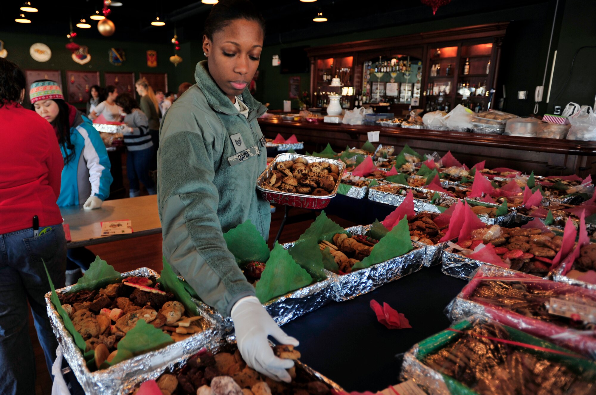Staff Sgt. Alicia Davis, 303rd Intelligence Squadron NCO in charge of knowledge operations, helps package cookies at the Osan Officers’ Club, Dec. 10, 2012, before delivery to unaccompanied service members through Operation Sweet Treat. Base volunteers worked together to bake cookies, brownies or any other sweet treat in hopes to spread holiday cheer. (U.S. Air Force photo/Airman 1st Class Alexis Siekert)
