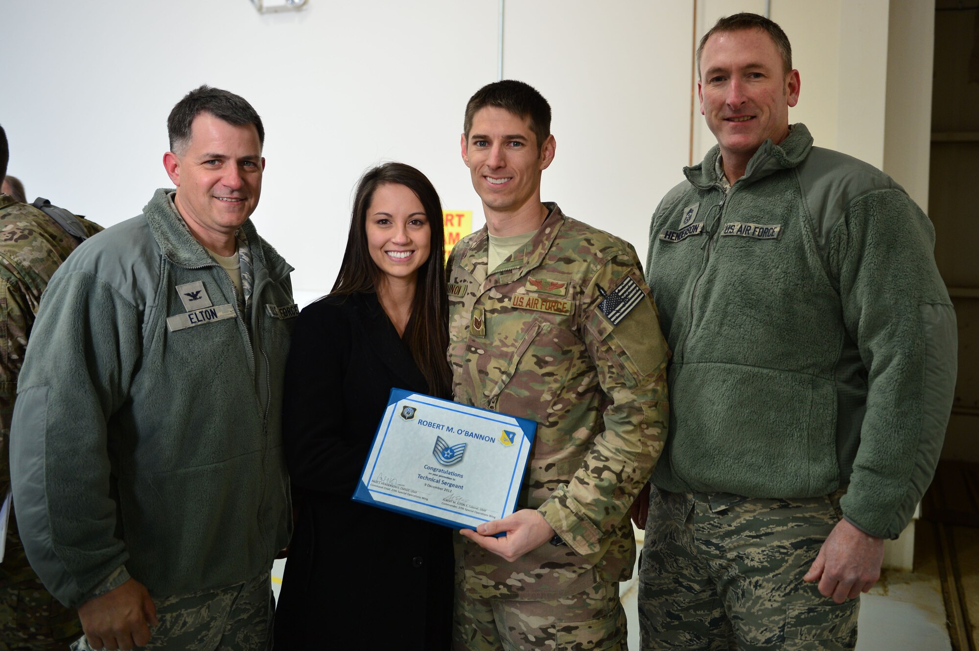 U.S. Air Force Col. Buck Elton, 27th Special Operations Wing commander, and Chief Master Sgt. Paul Henderson, 27 SOW command chief, present Staff. Sgt. Robert O'Bannon, 16th Special Operations Squadron, with a certificate congratulating him on a Stripes for Exceptional Performers promotion, Dec. 4, 2012. O'Bannon was promoted due to his consistent record of exceptional performance and service. (U.S. Air Force photo/Airman 1st Class Eboni Reece)