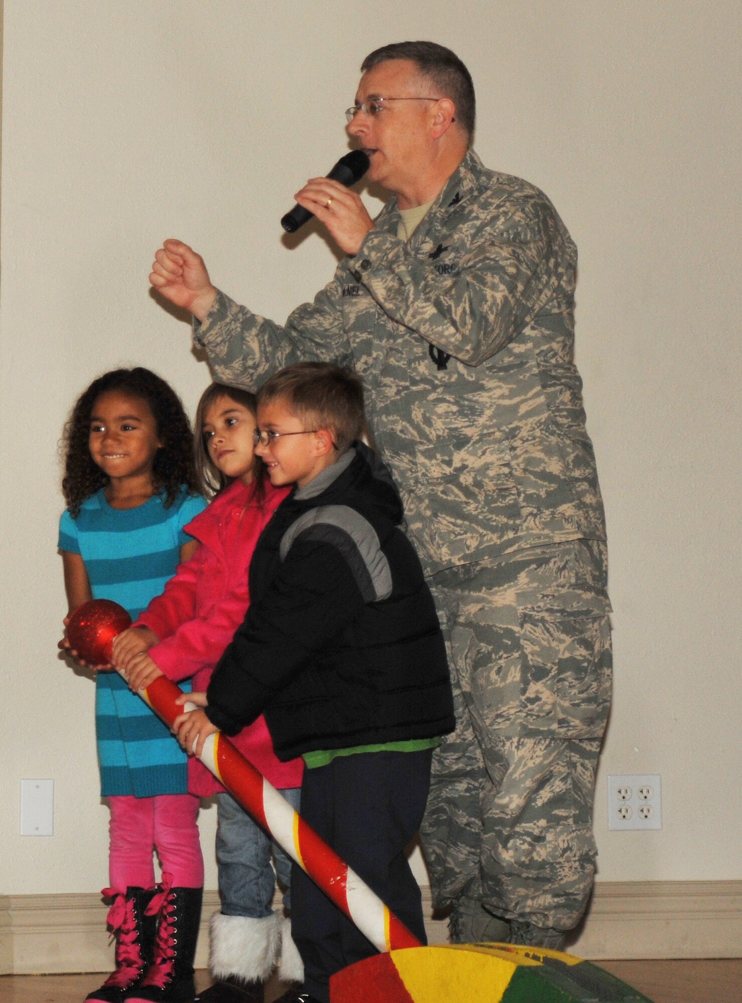 Colonel Sam McNiel, 61st Air Base Group commander is helped by three family members in lighting the Fort MacArthur Community Center Christmas tree, Nov. 30. The annual tree lighting event featured music, food and a visit from Santa Claus.  (Photo by Sarah Corrice)
