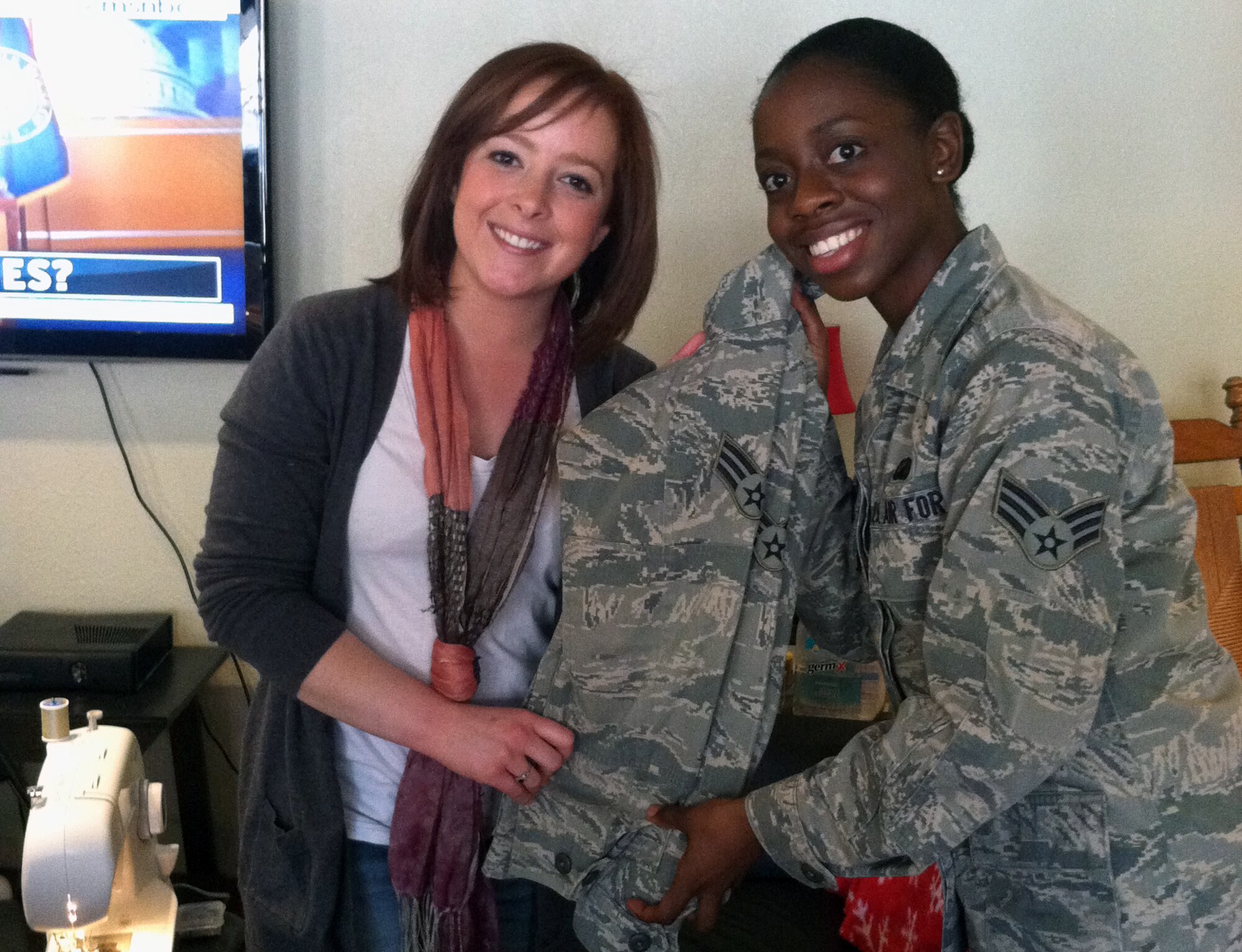 Senior Airman Patrika Patrick, 49th Comptroller Squadron finance technician, and Laura Richard, a volunteer at the reFUEL Café at Holloman Air Force Base, N.M., pose for a photo with a uniform of Patrick’s on which Richard sewed new E-4 stripes for free Dec. 4. The 49th Wing chapel staff hosted a “Soup-n-Stripes” event for Airmen who have recently been or will soon be promoted, offering soup and a host of volunteers who sewed the new rank on immediately.  This was the first event of its kind. (Courtesy photo)