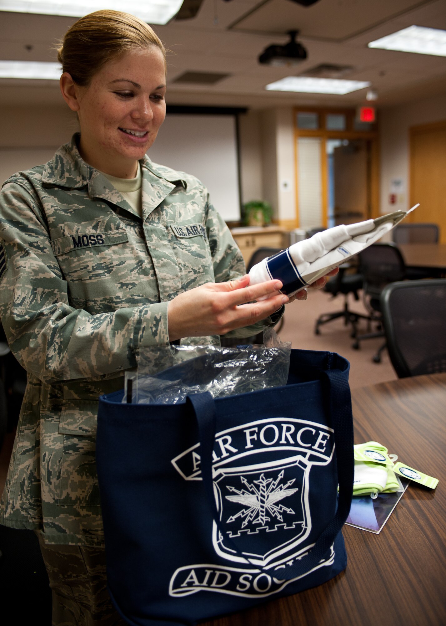 Staff Sgt. Karleigh Moss, 28th Comptroller Squadron financial analyst, opens up the gift bag she received during a Bundles for Babies class held by the Airman and Family Readiness Center at Ellsworth Air Force Base, S.D., Dec. 5, 2012. Each participant from the class received a bundle of baby items donated by the Air Force Aid Society. (U.S. Air Force photo by Airman 1st Class Alystria Maurer/Released)