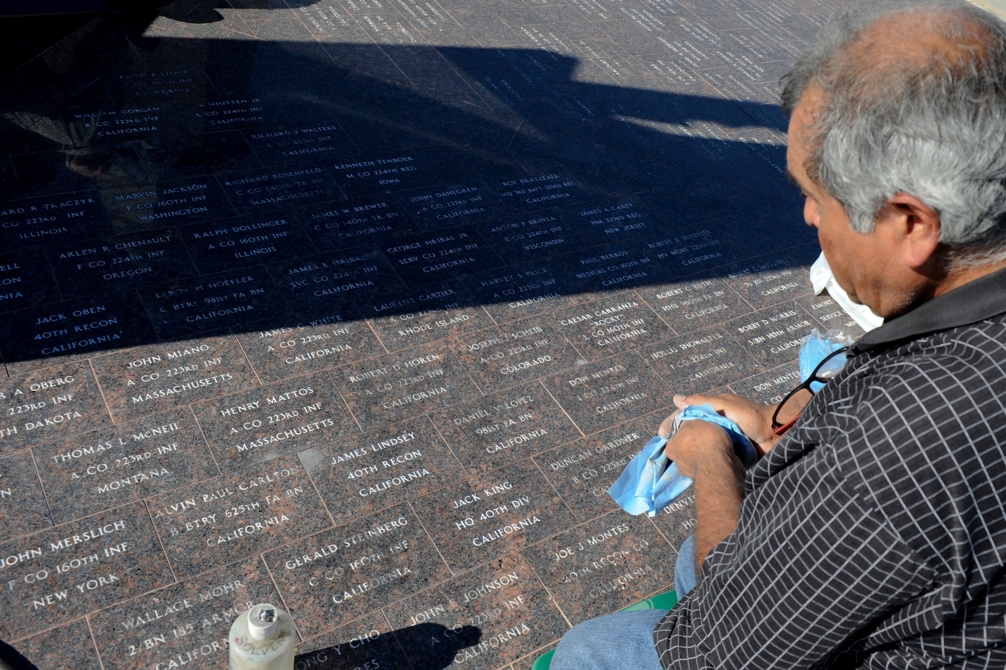 VANDENBERG AIR FORCE BASE, Calif. - Augie Ortiz, Santa Barbara Monumental Company certified memorialist, wipes down the new names that have been added at the 40th Infantry Division Korean War Memorial here Monday, Dec. 10, 2012. The 40th lost nearly 400 soldiers in a year during the Korean War. To honor the fallen, names are etched into bricks at the memorial yearly. (U.S. Air Force photo/Airman Yvonne Morales) 