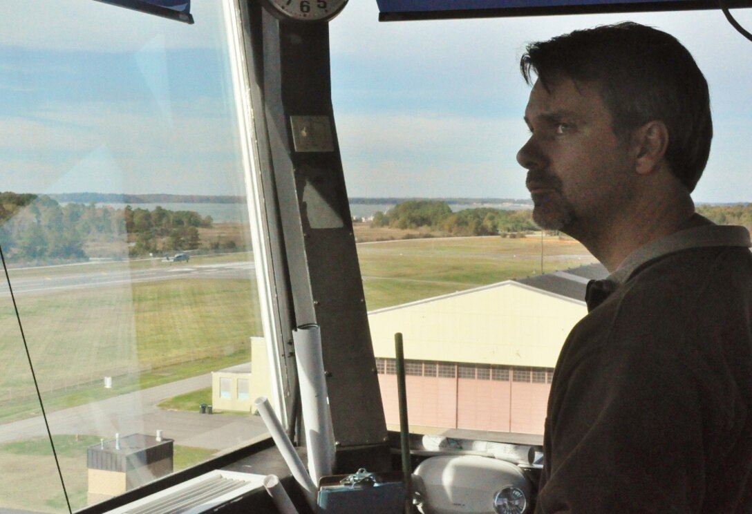 John Musser, the Felker Army Airfield manager, watches the skies from the air traffic control tower as a U.S. Navy SH-60 Seahawk performs a sharp bank turn over the airfield at Fort Eustis, Va., Nov. 7, 2012. The Navy uses the airfield and its airspace to train SH-60 Seahawk pilots stationed on the south side at Naval Station Norfolk. Musser said Felker AAF provides a perfect environment for pilots-in-training to perform a wide variety of scenario-based training unavailable in Norfolk. (U.S. Air Force photo by Senior Airman Jason J. Brown/Released)