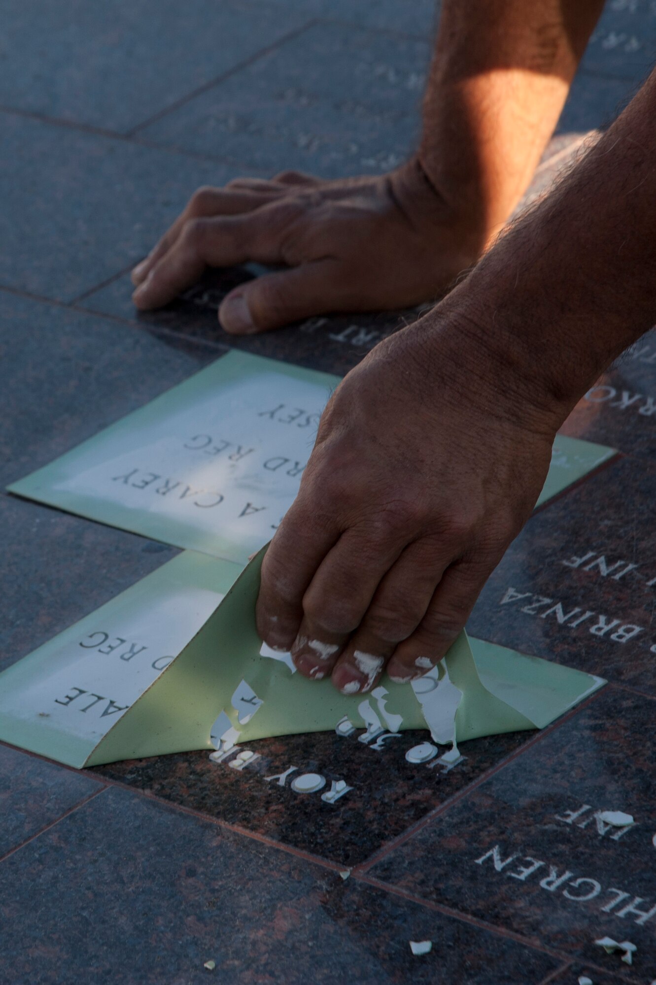 VANDENBERG AIR FORCE BASE, Calif. –Augie Ortiz, Santa Barbara Monumental Company certified memorialist, peels rubber molding from a marble bricks at the 40th Infantry Division Korean War Memorial here Monday, Dec. 10, 2012. The 40th lost nearly 400 soldiers in a year during the Korean War. To honor the fallen, names are etched into bricks at the memorial yearly. (U.S. Air Force photo/Senior Airman Lael Huss)