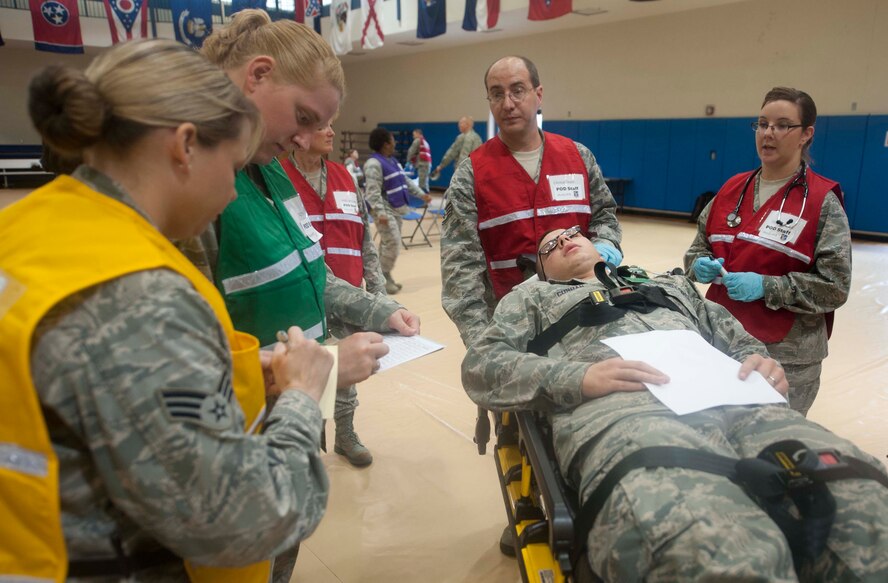 U.S. Air Force Airman 1st Class Matthew Curran, 723d Aircraft Maintenance Squadron avionics system apprentice, receives medical attention after being stung by a bee in a scenario during a disease containment  exercise at Moody Air Force Base, Ga., Dec. 7, 2012. 23d Medical Group Airmen part of a point of distribution team received injects throughout the exercise to see how they handle various situations. (U.S. Air Force photo by Airman Paul Francis/Released) 

