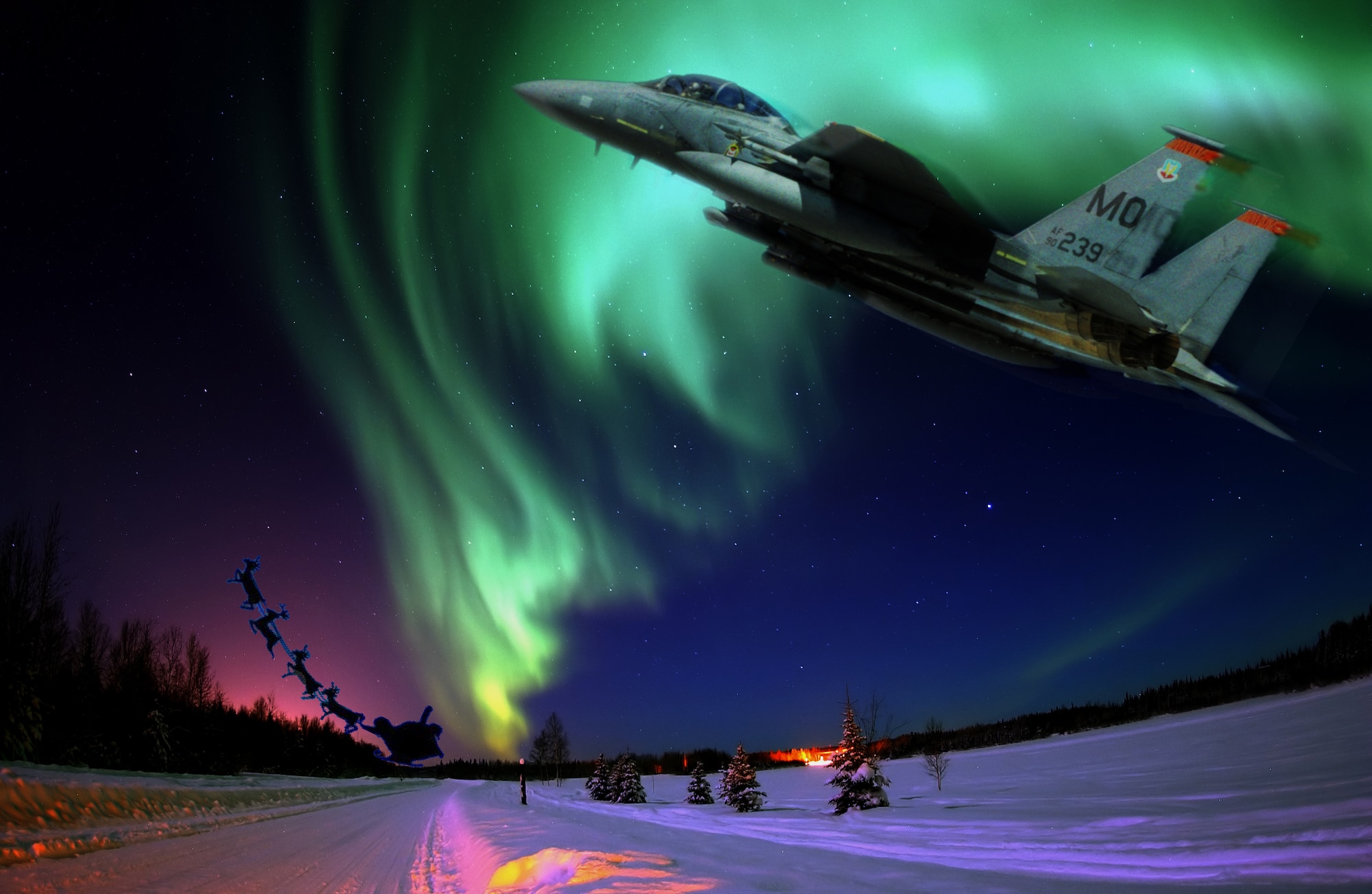 MOUNTAIN HOME AIR FORCE BASE, Idaho – An F-15E Strike Eagle rushes to assist Santa Claus and serves as his wingman as he delivers presents around the world. Flying a ‘sleigh’ powered by two Pratt and Whitney engines and capable of flying at speeds in excess of 1,800 mph, Maj. Kristin Wehle, 366th Fighter Wing F-15E pilot, believes she and other Air Combat Command pilots could be Santa’s perfect wingman, she said. (U.S. Air Force photo illustration/Master Sgt. Kevin Wallace/RELEASED) -Original Aurora Borealis photo by Senior Airman Joshua Strang