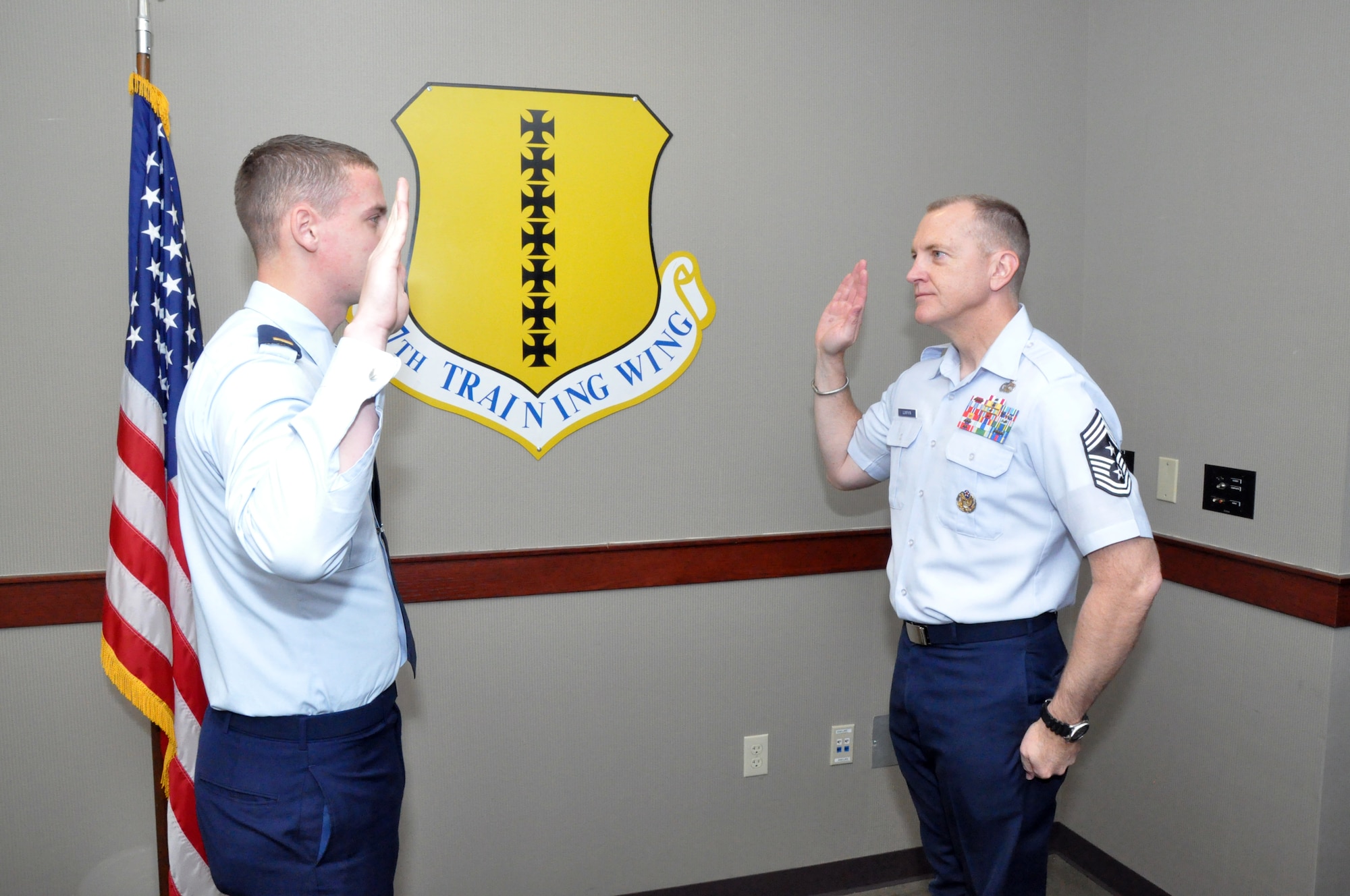 GOODFELLOW AIR FORCE BASE, Texas – Chief Master Sgt. Scott Lumpkin, 17th Training Wing Command Chief Master Sergeant, reenlists at the Norma Brown building here Dec. 10. He chose 2nd Lt. Kyle Rich, 315th Training Squadron student, to reenlist him to express that even a second lieutenant out ranks a chief master sergeant. (U.S. Air Force photo/ Airman 1st Class Joshua Edwards)