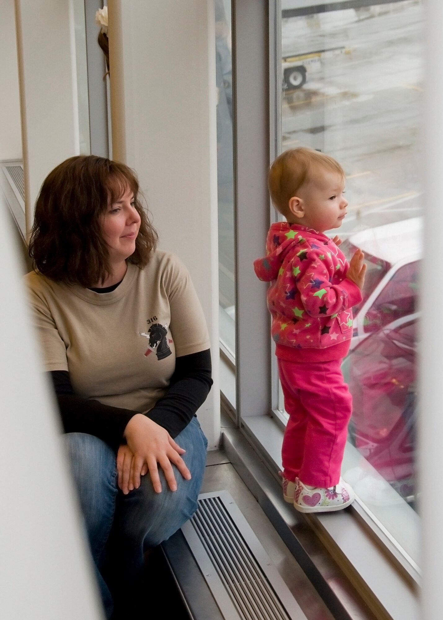 GRISSOM AIR RESERVE BASE, Ind. -- Melody Scalf and her niece watch an aircraft taxi that transported the young girl?s father and 23 other Soldiers to Fort Dix, N.J., for predeployment training Dec. 7. The soldiers from the 316th Psychological Operations Company are deploying to Africa for a 10-month deployment in support of Operation Enduring Freedom. (U.S. Air Force photo/Staff Sgt. Ben Mota)