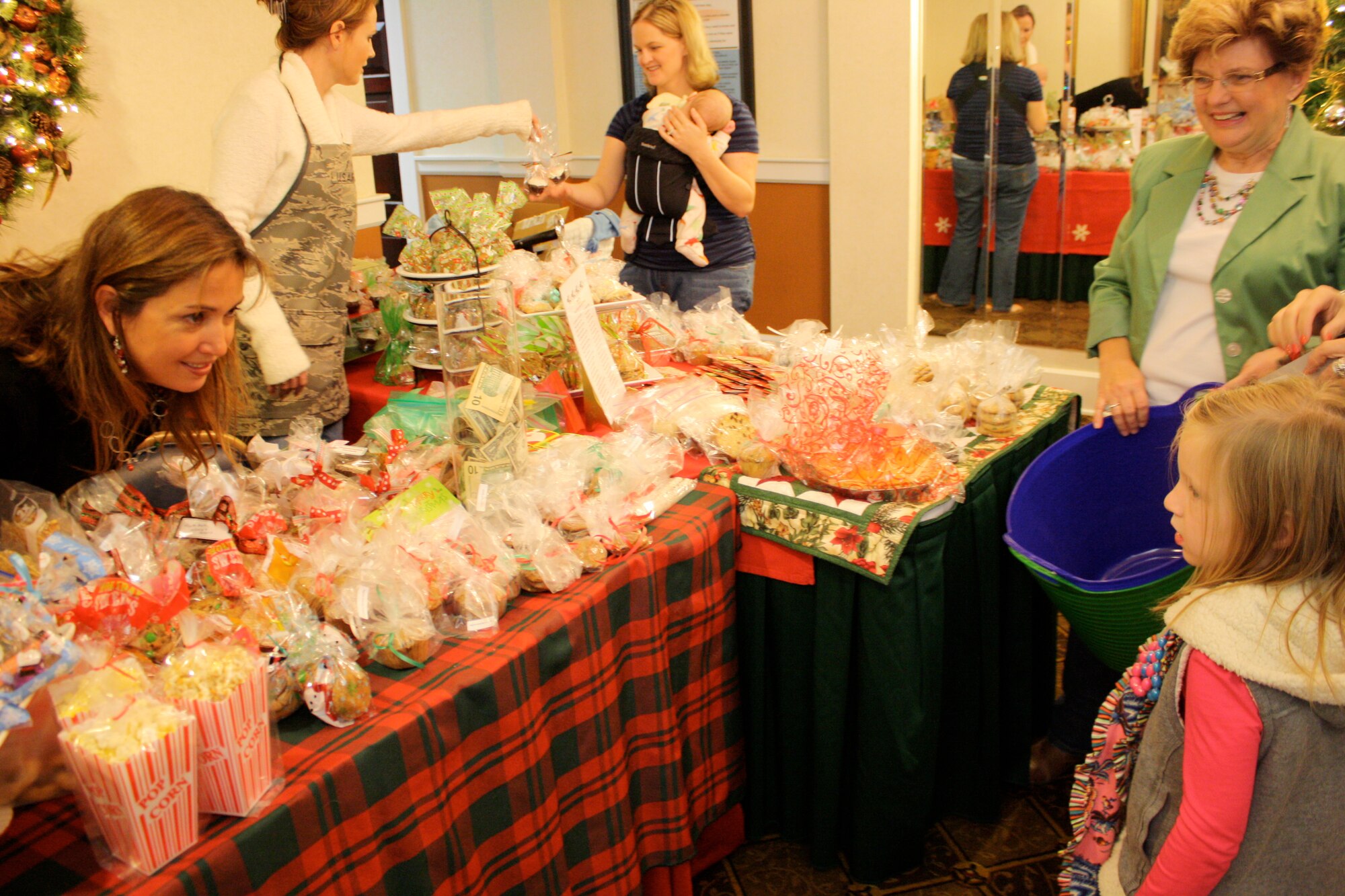 Sarah Allen and Lisa Pugh, members of the Maxwell-Gunter Officers' Spouses' Club, greet guests to the club's annual Holiday Mini Market as they sell cookies, brownies and sugary treats baked by the women of MGOSC. (U.S. Air Force photo by Rebecca Burylo)