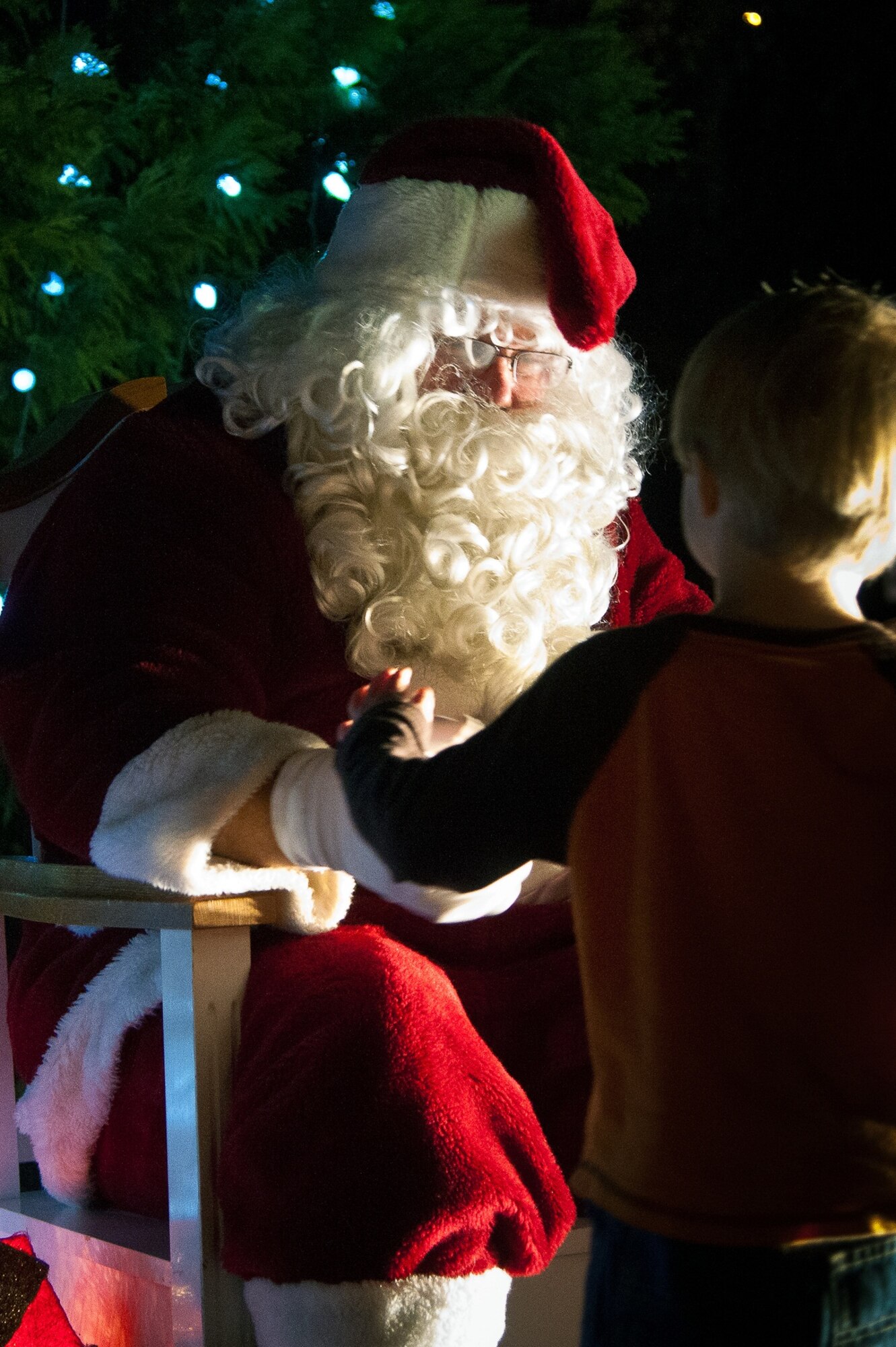 Santa waits to hear a child’s wishes Tuesday during the Gunter tree lighting event. (U.S. Air Force photo by Donna Burnett)