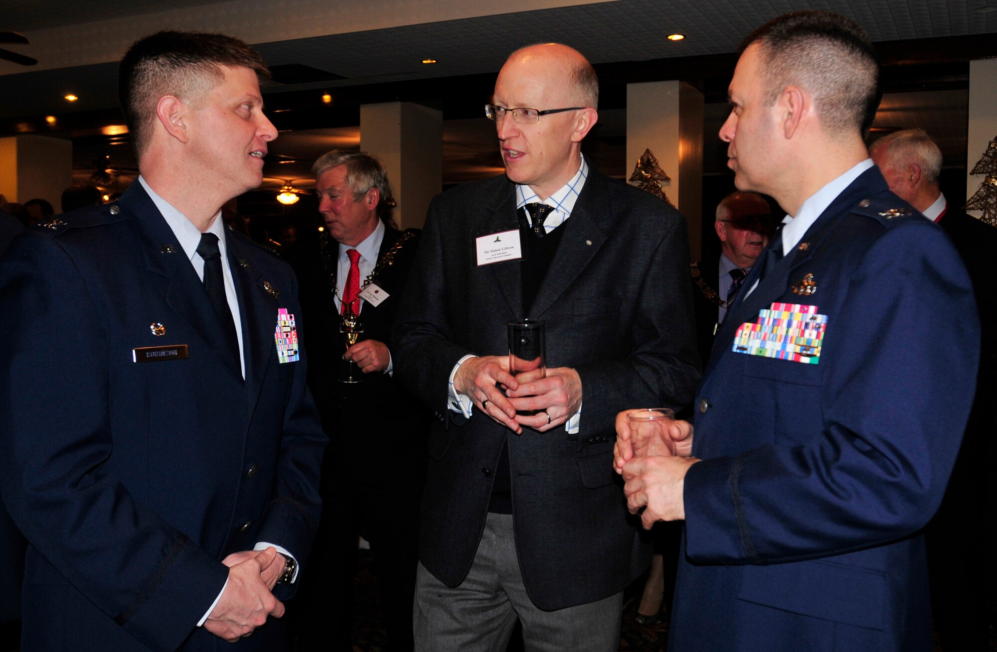 ROYAL AIR FORCE LAKENHEATH, England - Col. Kyle Robinson, 48th Fighter Wing commander, Simon Gibson, RAF Mildenhall British-American Committee member and Col. Joseph Rushlau, 100th Maintenance Group commander, speak during the RAFs Lakenheath and Mildenhall's 2012 Yuletide Reception at Eagle's Landing Dec. 7, 2012.  Leadership from both bases welcomed community leaders to the event to celebrate the holiday season. (U.S. Air Force photo by Senior Airman Tiffany M. Grigg) 