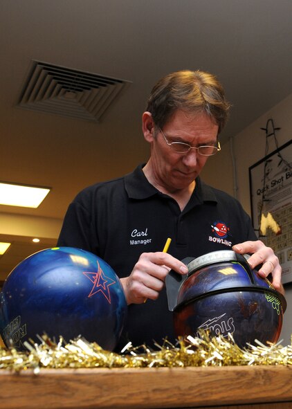Carl Schlesinger, 100th Force Support Squadron bowling center manager from Dover, Del., measures a bowling ball prior to drilling Dec. 7, 2012, at RAF Mildenhall, England. The bowling center offers glow bowling on Friday and Saturday nights as well as bowling for only $1 on Wednesdays. (U.S. Air Force photo by Gina Randall/Released)