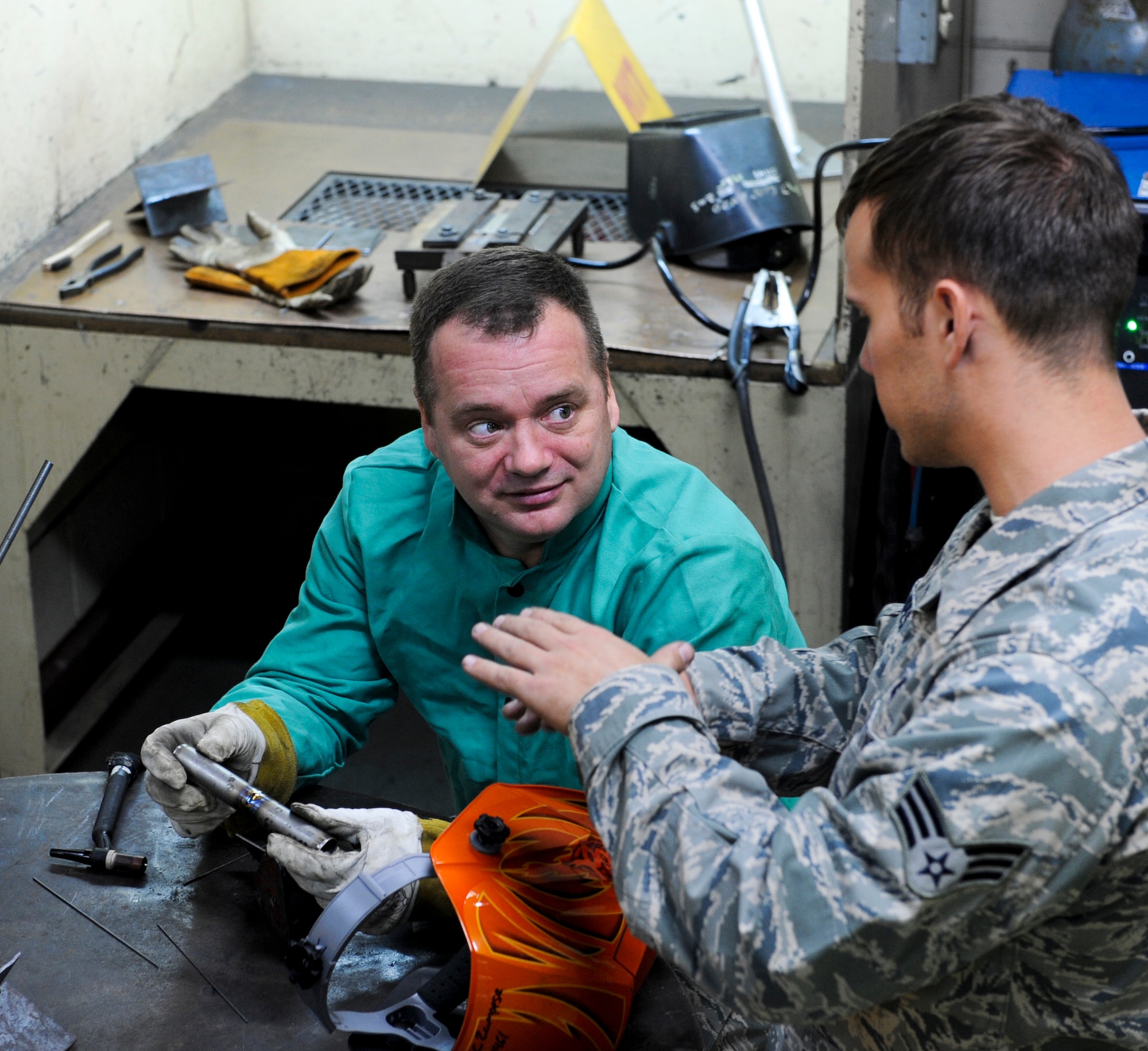 U.S. Air Force Senior Airman Christopher Zampese, 18th Equipment Maintenance Squadron aircraft metals technology technician, presents Col. Brian McDaniel, 18th Wing vice commander, with an example of a well done tungsten-electrode inert gas welding technique on Kadena Air Base, Japan, Dec. 6, 2012. TIG is a slower welding technique, but the quality of weld tends to be cosmetically better because there is no weld splatter and it has a clean finish, according to Senior Master Sgt. Roger Starcher, 18th EMS Fabrication Flight superintendant. (U.S. Air Force photo/Airman 1st Class Justin Veazie)