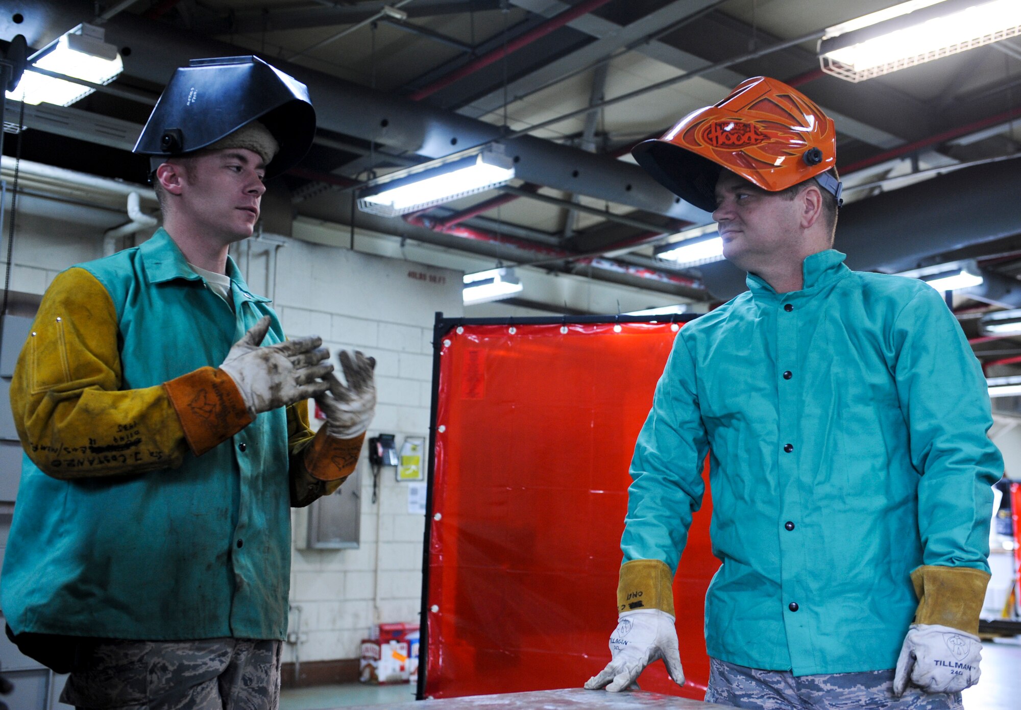 U.S. Air Force Staff Sgt. Justin Costanzo, 18th Equipment Maintenance Squadron aircraft metals technology craftsman, talks with Col. Brian McDaniel, 18th Wing vice commander, on the different welding techniques that they will be performing on Kadena Air Base, Japan, Dec. 6, 2012. McDaniel said he wanted to learn how to weld because his father used to weld and would boast about how good he was, so he wanted to try it out himself to show that he could do it too. (U.S. Air Force photo/Airman 1st Class Justin Veazie)