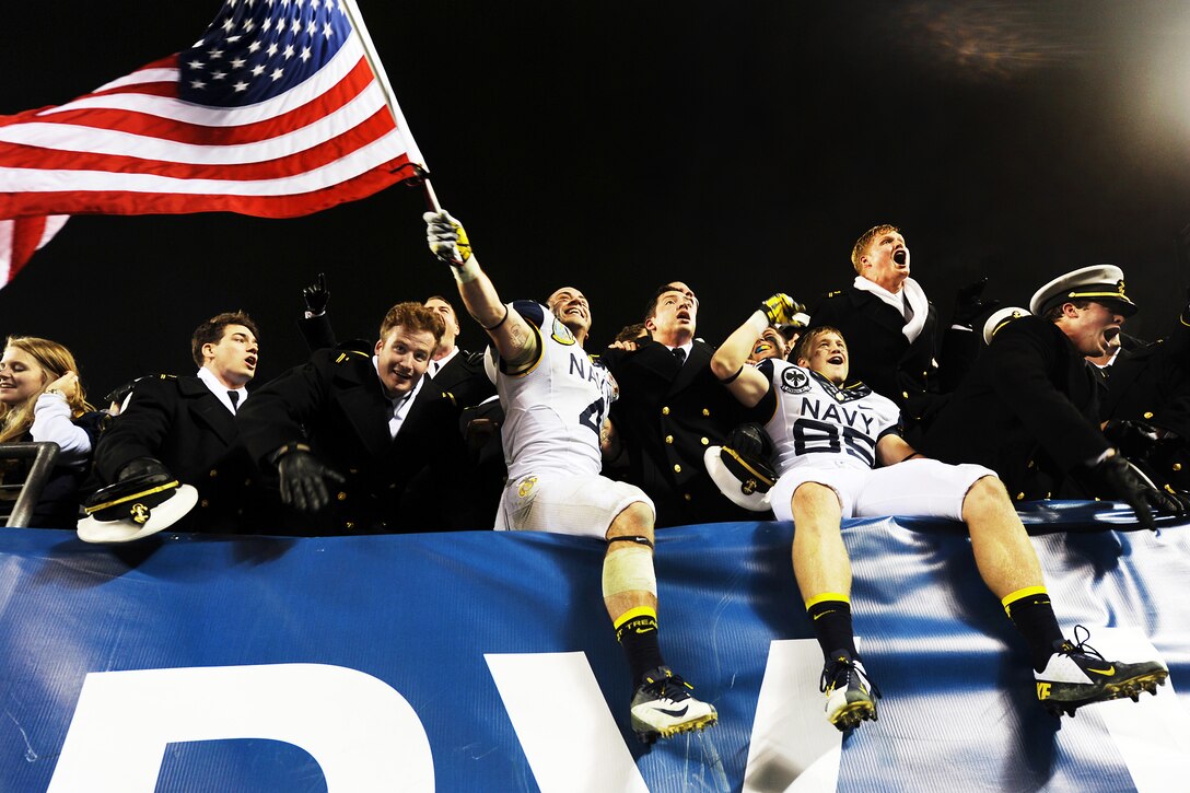 Naval Academy player Bo Snelson waves an American flag while celebrating the Navy's 17-13 win over Army at the Lincoln Financial Stadium in Philadelphia, Dec. 8, 2012. 