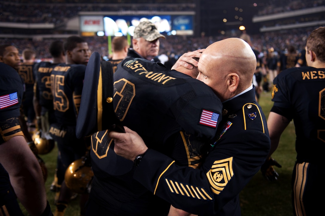 Army Command Sgt. Maj. Todd Burnett, right, command sergeant major of the U.S. Military Academy Corps of Cadets, hugs Army Black Knights quaterback Trent Steelman, left, after a tough game against Navy at Lincoln Financial Field in Philadelphia, Dec. 8, 2012. Navy beat Army 17-13.