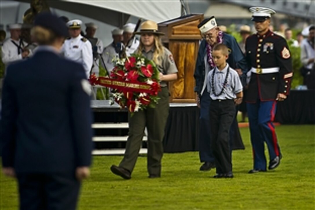 U.S. Marine Corps Staff Sgt. Stephen Cameron escorts former Navy Petty Officer 1st Class Paul Goodyear during the presentation of the Marine Corps wreath during a wreath laying ceremony in remembrance of the anniversary of the Japanese attack on Pearl Harbor at the World War II Valor in the Pacific National Monument, in Honolulu, Dec. 7, 2012. Cameron is assigned to Marine Aviation Logistics Squadron 24, Marine Corps Base Hawaii.