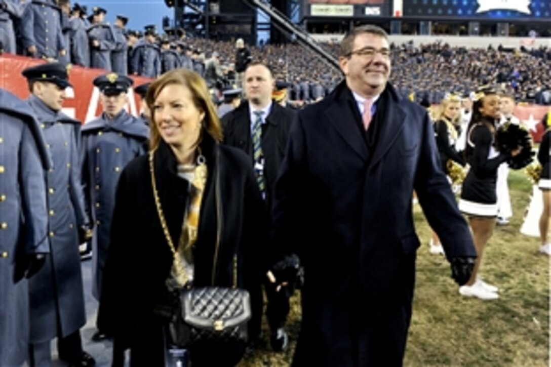 Deputy Defense Secretary Ashton B. Carter and his wife, Stephanie, walk along the sidelines as they join the Army side at halftime during the Army-Navy football game at Lincoln Financial Field in Philadelphia, Dec. 8, 2012. 