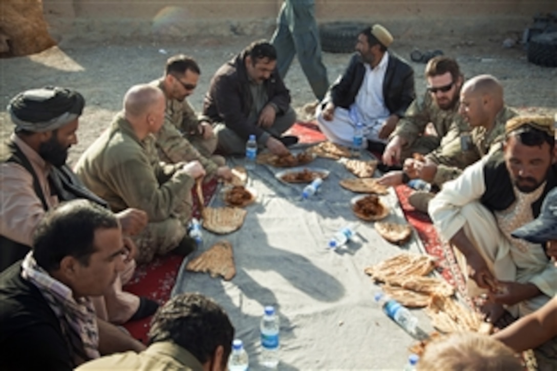 Afghan local and national policemen talk with coalition force members during a meeting to discuss self-sustainment of the police forces in Afghanistan's Farah province, Dec. 3, 2012. 
