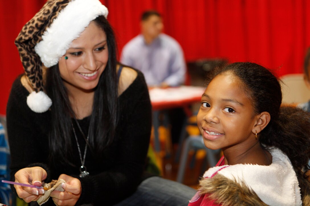 A young child smiles for the camera as she gets her face painted at the Marine Corps Base Camp Lejeune Headquarters and Support Battalion Holiday Jubilee at the Goettge Field House Dec. 6. The jubilee started at 5 p.m. and featured two magicians and a raffle, along with dinner.